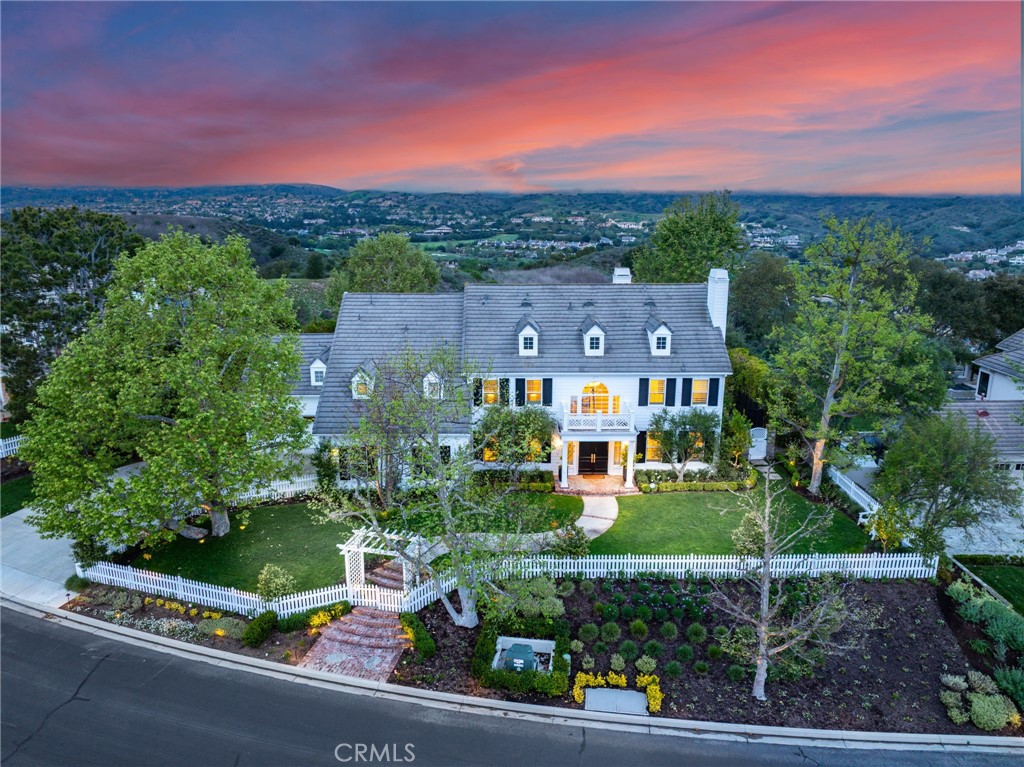 Welcome to 48 Panorama, an exquisitely remodeled masterpiece that blends sophisticated design with modern luxury. Situated on a single-loaded street, this home offers breathtaking panoramic views from every room on both sides. Spanning 5,100 sqft. with 5 bedrooms and 5 bathrooms, this stunning residence sits on an expansive 23,000+ sqft. lot. Step through the charming white picket fence, across the lush grass, and through the grand double front doors, where abundant natural light, an open floor plan, and exquisite finishes welcome you. The white oak wood flooring extends throughout both levels, leading to the formal dining room on the left and the living room with a bar on the right, both adorned with beautiful wainscoting—perfect for indoor gatherings. Flowing effortlessly into the family room, floor-to-ceiling La Cantina doors span its entire length, creating a seamless connection to the outdoors. A stunning built-in entertainment center and a marble-surround fireplace add warmth and sophistication. The chef’s kitchen is both elegant and functional, featuring a top-of-the-line premium Thermador appliances, marble countertops, an oversized island, a walk-in pantry, and a stylish backsplash. The main level also includes a secondary bedroom with an ensuite bathroom, perfect for a home office or guest suite, offering serene views through French doors. A mudroom behind the ensuite provides built-in storage and a refrigerator, while a spacious 4-car garage and large driveway offer ample parking.Ascending the sweeping staircase, you'll find a spacious bonus room with breathtaking views—a perfect retreat for relaxation or entertainment. The primary suite is a private oasis with a sitting area, panoramic views, and a custom walk-in closet with a center island. Its spa-like bathroom features marble floors, a soaking tub, dual vanities, a makeup vanity, and a luxurious shower.Upstairs also includes three secondary bedrooms, two remodeled bathrooms, a laundry room, and an additional staircase.The backyard is an entertainer’s paradise with a sleek pool, slide, built-in BBQ, pizza oven, heaters, a trampoline, fire pit, putting green, and spectacular views.Additional upgrades include solar panels, a water softener system, recessed lighting, designer fixtures, Sonance speakers, new AC units, and more.Don’t miss your opportunity to call 48 Panorama home—where elegance, comfort, and unparalleled views come together in perfect harmony.