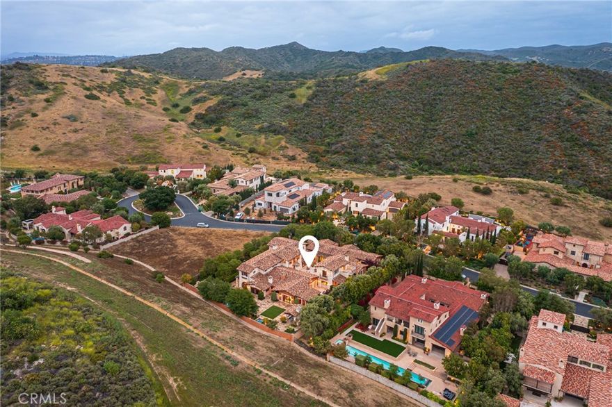 Renowned for its exclusivity, natural beauty and premium luxury living, Irvine’s guard-gated Shady Canyon community is among the most prestigious private enclaves in Southern California. Near the end of a peaceful cul-de-sac street, this lavish estate presents the pinnacle of success at Shady Canyon, with a phenomenal custom residence and walled and gated grounds rivaling those in Beverly Hills, the Hamptons and beyond. Subtle in its beauty and harmonizing with its natural setting, the estate’s homesite extends nearly .82 acres and weaves intimate patios, sprawling lawns and manicured landscaping with a large central courtyard, a saltwater pool with spa, an open-air living room, fireplaces and two outdoor showers. The outdoor kitchen is better equipped than those found in most homes, complete with a pizza oven, Viking range, Sub-Zero refrigerator, exotic stone countertops, an island and wine cooler. Countless traditional and arched French doors provide easy passage between indoor and outdoor living areas, creating numerous spaces for formal and casual entertaining, impromptu parties and easy relaxation. A formal foyer and gallery-style halls welcome guests into a sophisticated residence of undeniable refinement and luxury, with handcrafted woodwork, wood and marble flooring, romantic archways, and ceilings that are vaulted, beamed, cross-loin, barrel or tray, depending upon the room. An elevator serves all three levels, with the main floor hosting an enormous formal dining room that opens to the courtyard on one side and a patio on the other; a great room with built-in entertainment center and slideaway glass doors to a loggia; and a family room that also opens to the loggia. Unparalleled in design and amenities, the kitchen displays an oversized island, a massive walk-in pantry, two butler’s pantries, a separate breakfast room, two built-in refrigerators, a home-management center, built-in Meile coffee station, two farmhouse sinks, a Viking range and Thermador appliances. Approximately 17,246 square feet, the impressive residence is home to five en suite bedrooms and seven full and three half baths, including a primary suite on the main level and another by itself on the top floor. A separate upper floor features a versatile gym/studio, and the subterranean level boasts a game room, wine cellar, and a tiled garage for over 17 vehicles that features a work bay with hydraulic lift, hobby and storage rooms, and a turntable for easy parking.