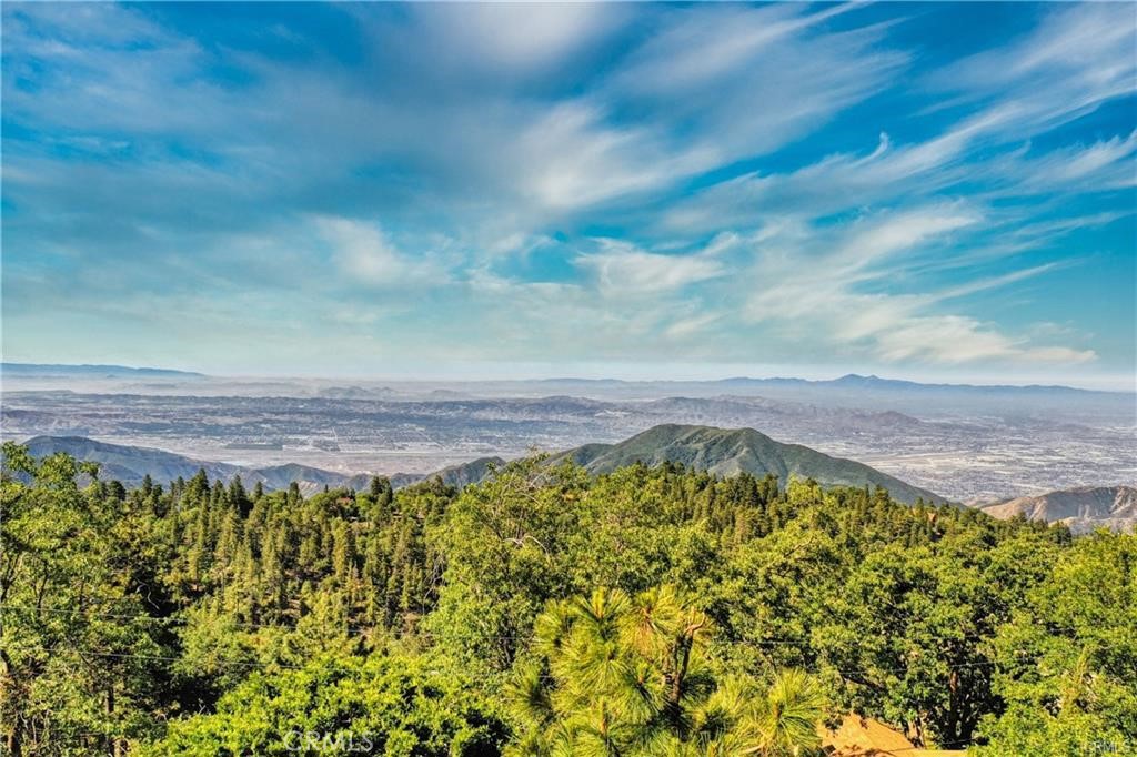 Nestled in the heart of Running Springs, this gently sloping 7,000 sq ft parcel offers a stunning canvas for your dream mountain retreat—whether it’s a full-time home, a serene getaway, or an investment project. Picture waking up to breathtaking sunrises and winding down with fiery sunsets, all while enjoying sweeping panoramic views of the rolling foothills and twinkling city lights below. Located less than 10 minutes from charming local shops and cozy restaurants, and just 15 minutes from Snow Valley’s thrilling ski slopes and SkyPark’s year-round adventure—this lot delivers on both convenience and outdoor living. During warmer months, hit the trails for mountain biking, and when winter arrives, carve through fresh powder just a short drive from your doorstep. Commuting is a breeze too—just 25 minutes to the 210 Freeway in Highland, making workweek transitions smooth and easy. With all public utilities available at the street—electricity (SoCal Edison), gas (SoCal Gas), water and sewer (Running Springs Water District)—and reasonable hookup fees, this parcel stands out as an affordable and smart choice compared to other mountain communities. Don’t miss this golden opportunity to claim your slice of alpine paradise for just $40K—come explore it today and envision what’s possible.
