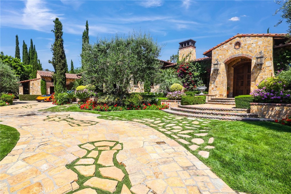 Discover this timeless Exquisite Paradise at the end of a private, gated cul-de-sac in the Prestigious Los Ranchos Estates. This 6-bedroom, 8-bathroom masterpiece welcomes you with grandeur and elegance, featuring high colliding barrel-rolled ceilings, a Gourmet Chef's Kitchen, and a breathtaking Great Room. Step inside and be captivated by the expansive entertainment areas, framed beautifully by groin vaulted ceilings and stunning architectural details. Indulge in the finest luxury finishes, including French Bone Merrier stone, exotic imported marbles, Venetian plaster, and bronze embellishments. The estate also boasts solid walnut hand-carved cabinets, a library-style office, billiards room, formal dining room, wine cellar, state-of-the-art technology, and a separate guest retreat, all thoughtfully integrated into an open living space. The exquisitely landscaped grounds showcase a rock waterfall pool/spa, a separate pool house with a theater, a large entertaining terrace, BBQ area, and a sunken tennis court. This property includes a water well to support all landscaping and irrigation, ensuring lush, green surroundings year-round. Offering maximum privacy and tranquility, this estate represents exceptional quality and unparalleled luxury living!