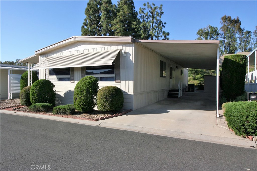 Senior park, space rent is $1,1115/Mo.This delightful home is well maintained and very light & bright. Berber carpet and white painted walls throughout.
The recently painted exterior has a large open deck, low maintenance landscaping and a shed in the driveway. The furnace and A/C. are newer and home has copper plumbing. The kitchen has white Formica counter tops, new dishwasher, gas cook top and oven. Kitchen is open to spacious dining area or den. Both bath rooms are updated. All furnishings included. Great opportunity for a well priced home in this 5 star Community.