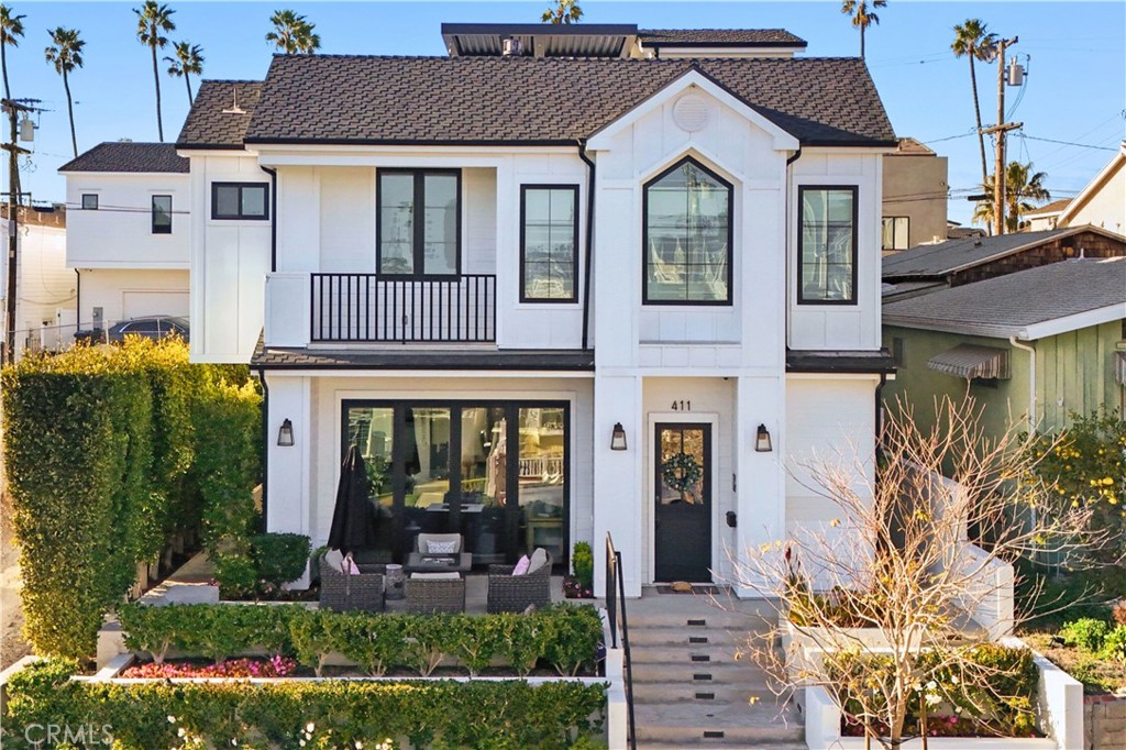 Experience Corona del Mar living at its finest in this stunning custom home. Located just a short walk from coveted beaches and fine dining and shopping in the village, this impressive property boasts a rare 43’ frontage and nearly 2,700 sq ft of luxurious space. A Dutch door entry welcomes you into the sophisticated and elegant interior, where you’ll enjoy hardwood floors and a fireplace in the living area, which opens seamlessly to tiled patios adorned with terraced gardens, privacy hedges, and mature roses. Enjoy 12’ ceilings, large windows, and massive folding doors flooding the space with abundant natural light. The chef's kitchen showcases gorgeous countertops, ample cabinetry, counterspace, and storage, and top-of-the-line appliances such as a Wolf 8-burner range and microwave, and a Sub-Zero refrigerator and wine fridge. The large kitchen island, complete with a farmhouse sink and seating, is perfect for entertaining, with a separate dining space just off the kitchen. A downstairs en-suite bedroom, laundry room, and half bath offer further convenience. Upstairs, three more en-suite bedrooms await, including a primary suite with vaulted ceilings, a private balcony, fireplace, spa-like bath, and walk-in closet. On the third floor, the specious rooftop deck offers panoramic views of the sparkling city lights and the iconic Goldenrod palm trees. Enjoy Sonos surround sound, custom shades, a security system, an attached garage, side-by-side parking, and ample storage throughout. With an amazing location near the village’s best restaurants and boutiques, exquisite beaches, and top-rated schools, this property is truly a dream come true.