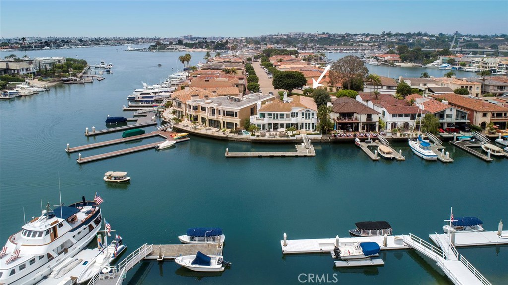 Possibly the best boat dock configuration in Newport Harbor, capable of handling at least a 90 foot vessel, plus one or more additional boats. There is seventy-five feet of bay frontage, 4550 square feet of living area, and a four car garage. The interior of this Richard Dodd designed home has recently been beautifully renovated by noted designer Anna Marshall.
Move right in and enjoy the large terrace for those fabulous evenings of al fresco dining. The expansive master suite with fireplace and lovely private deck will delight the senses. And there is enough closet space for two clothes collectors. There is a wonderful library style office with fireplace and wet bar that could become a fourth bedroom. This is what every boater desires, a really upscale home with space for all the toys.