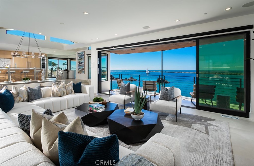 Showcased on a trophy bluff-top dream lot in one of the most exclusive coves in the world, China Cove, suspended above water, 2889 Way Ln is arguably the most treasured & distinguishable custom home to be prominently positioned within the iconic mouth of the Newport Beach Jetty. After a rigorous 6 year process, completed in 2022, this irreplaceable waterfront achievement embodies masterful craftsmanship, divine modern architecture, set against unparalleled views of the Pacific Ocean’s sparkling waters, Catalina Island’s rolling cliff-sides, captivating boat activity flowing in & out of the harbor, marine life, & picturesque sunsets year-round. The newly redesigned turnkey residence showcases bright & open-concept living spaces, entertainment-ready outdoor space, & countless thoughtful design features. A beautiful symphony of soft contemporary design & effortless flow create a truly unique experience of space; beginning with a welcoming foyer and oversized great room, dining room with vaulted ceilings, offering awe-inspiring unobstructed sunrise to sunset panoramas from nearly every perspective. Impeccable craftsmanship is on display in the chefs kitchen, lined with sleek custom cabinetry, pro-series appliances, a marvelous 16’ seven person waterfall island, & stone countertops throughout. Spanning ~4,642 SF, the residence intertwines the indoor and outdoor spaces through the use of oversized glass windows & Fleetwood sliding doors, which open to multiple wraparound balconies offering sweeping ocean views & brilliant coastline frames, as well as a central courtyard with outdoor fireplace, BBQ, & various seating options. The lower level space is the perfect setting to host with walk-in bar, ocean front balcony, & dedicated powder room. The residence is highlighted by 4 beds & 1 functioning as home office + 5 baths. Ascend to a supremely private primary suit that spans the entirety of the upper level & opens up to a viewing balcony above the courtyard. Unwind by the fireplace, immerse yourself in the soothing sound of waves crashing below, indulge in the spa like bath outfitted with designer stonework, free standing soaking tub, rain shower, dual vanities, & generously appointed walk in closet. Additional home features include a 3 car garage plus driveway space for an additional 3 cars, smart home automation, & security. This legacy estate is just steps away form China Cove beach, Pirates Cove, Main beach, CdM Village, award-winning schools, & entertainment.