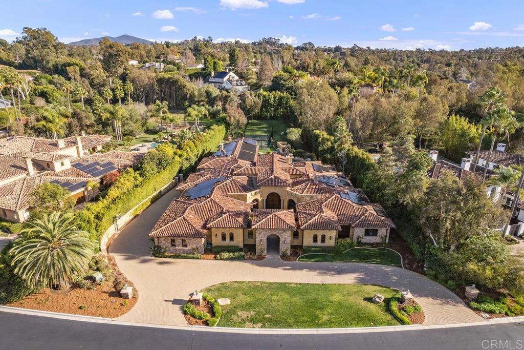 Resort living at its finest on the coveted North Side of private Fairbanks Ranch. This palatial single level estate has been masterfully designed with an eye towards craftsmanship and architectural magnificence. Walking through the private front courtyard, you are greeted by the sounds of soothing fountains before entering the extraordinary residence. Venture down the wide halls into the "Great Room" with high vaulted ceilings and floor to ceiling glass doors that open to a world-class backyard with unlimited entertaining opportunities. Grand-scale luxury everywhere you look with high end finishes, brilliant crystal chandeliers/sconces and mesmerizing views to the inviting backyard oasis. Featuring 5 spacious ensuite bedrooms, exceptional office/library retreat, 8-seat movie theatre, ultimate Family Room/Kitchen "Great Room" bathed in natural light, temperature-controlled wine room, 6-car garage for the passionate car collector, electric car charging station and a 2022 installed solar system. Private 1+ acre site with lush landscaping, resort-style pool with spa and beach entry, rock grottos and cascading waterfall features. New state-of-the-art Padel/Pickleball Court with 12-foot tempered glass walls, putting green, grass volleyball court, heated cabaña with fireplace, wet bar, built in BBQ. An absolutely incredible family compound ! You will never want to leave home again, unless taking a short stroll to the nearby park, lake and walking trails. Enjoy hot air balloons overhead and all the other amenities this highly sought after 24-hr guard-gated community has to offer its residents