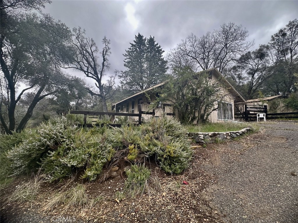 This is a nice 2 bedroom, 1 bath home located on a beautiful parcel in Oakhurst and is close to many amenities that Oakhurst has to offer. The home includes a shed, covered detached carport and most furnishings and items. Also included are 3 separate parcels 3.92+/- acre with the home, and 2 adjacent .23+/- acre and .32+/- acre parcels with a total of almost 4.5+/- acres of beautiful land. The home is being sold "As Is" due to some damage that was sustained to the roof, septic and water line. Buyers to verify the square footage of the home. A large room was added to the home, which is off the kitchen area, and the garage converted into a storage room.