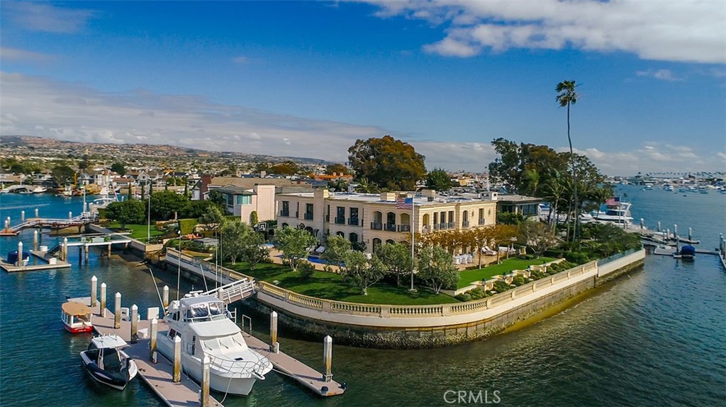 A landmark promontory location defining the spirit of the Newport Harbor – 18 Harbor Island. Here classic architectural structure meets a forward-thinking design aesthetic, creating a one-of-a-kind waterfront treasure with over 300 feet of bay frontage. With clean lines, open space and purity of form the re-mastered residence with a total building size of approximately 16,000 square feet lives graciously with large-scale rooms and a panorama of sublime water views. Beautifully and tastefully appointed the exquisite finishes and custom refinements are flawlessly employed. Abundant natural light cascades throughout the formal and informal spaces, illuminating the myriad bespoke details of this transformed neoclassic home. The grand-scale of the interior balances seamlessly with multiple exterior limestone terraces, flowing gardens, and a magnificent pool surrounded by the glistening waterfront and captivating, lively views of the harbor turning basin. A newly reconstructed yacht accommodation for a craft in excess of 120 feet, as well as additional boats and water toys is sited along the western portion of the estate grounds. Rich with history, the guard gated Harbor Island enclave is perhaps the most coveted address along the waterfront in Southern California. Poised at the island’s tip and transcending all others, the space and views afforded by this distinguished residence cannot be replicated.