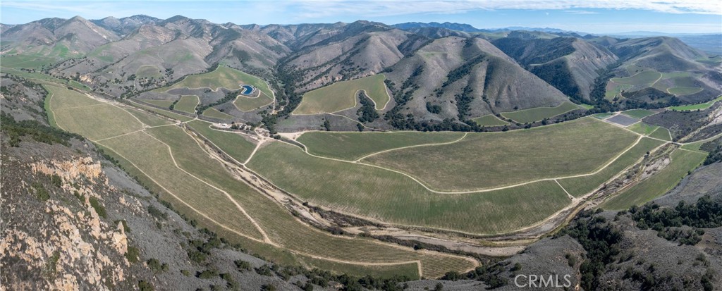 A vineyard of this caliber rarely comes to market. Developed by a world-renowned wine company for its ultra-premium brands, North Canyon Vineyard spans 1,672± acres in 2 parcels across San Luis Obispo and Santa Barbara counties in the heart of the Santa Maria Valley AVA.
Beyond its proven reputation for wine grape production, the property offers remarkable versatility for various high-value agricultural ventures. With ideal climate conditions, prime soil diversity, and reliable water resources, there is significant potential for conversion to high-value crops such as berries, leafy greens, and specialty vegetables, in addition to continued premium grape production.
With 919.8± planted acres of Pinot Noir, Chardonnay, and select white varietals, this top-tier estate sits in one of California’s most acclaimed winegrowing regions, where a unique transverse valley funnels cool Pacific breezes, extending hang time for optimal ripening. Positioned at elevations reaching 600 feet, the vineyard’s upper-bench shale rock soils produce world-class Pinot Noir, while the fertile valley floors yield high-quality Chardonnay, both commanding premium bottle prices.
Water security is a key asset, with six agricultural wells delivering 2,210± GPM, supplemented by natural water table recharge from the Twitchell Reservoir. With a history of excellence, a private and stunning setting, and a scale that supports long-term investment growth, North Canyon Vineyard is a legacy estate positioned for the future.
Wines sourced from this site have earned 90-96 point ratings, reinforcing its pedigree among the region’s most sought-after producers.
The adjacent parcel is APN 090-422-005 (CRMLS Listing ID: NS25058918). The 2 parcels are available for purchase either separately or together.
Offering Package available upon request.