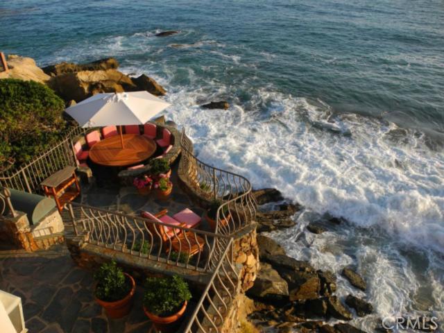 Perched on a promontory over the ocean, this iconic Laguna Beach estate offers a rare opportunity to experience the ultimate Southern California lifestyle. A "landmark" residence, this stunning 3-level home was meticulously rebuilt with extraordinary attention to detail, superior construction and contemporary conveniences. It neighbors Ruby Street Park and boasts unobstructed views from virtually every room. The sands of Woods Cove are below, accessed by a private staircase. A gated drive leads to a 2-story rotunda foyer and amenities including beamed ceilings, original wood floors, an elevator, 3 fireplaces, a steam shower and an open kitchen with vaulted ceilings, skylight, nook, marble counter tops and Viking range. The lower level includes a second kitchen, HDTV with surround sound and a circular slate patio with gas BBQ and built-in seating. A master suite of sumptuous proportions enjoys ocean views from three sides.