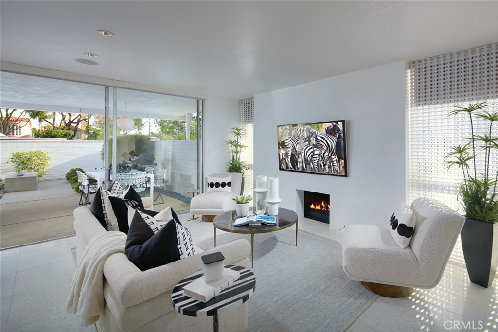 Chic, light, and ready to enhance your lifestyle, this impeccable single-story residence in the Sandcastle enclave of Corona del Mar epitomizes the allure of mid-century modern design. Floor-to-ceiling walls of glass flood the open-concept one-bedroom, one-bath floor plan with an abundance of natural light, while bespoke finishes, including terrazzo flooring throughout, up its wow factor. The unit's preferred corner location features a large backyard that is perfectly suited for entertaining with an open-air fireplace, professionally designed hardscaping, and covered patio. Characterized by custom window coverings and stylish built-in shelving, the fireplace-warmed living room opens to the generous outdoor space by way of sliding glass doors. Dine in the high-end kitchen where custom gloss-white cabinetry, generous island beneath swanky pendant lights, designer tile, and top-of-the-line appliances further enhance the sophisticated ambiance. High style is the hallmark of the ensuite bedroom, which offers direct access to the backyard and a luxe bath with a walk-in rain shower. Sandcastle residents enjoy exclusive access to a resort-style pool, spa, and two parking spaces in a secured parking garage. Situated near top-tier schools, Corona Del Mar Plaza, Fashion Island, beaches, Newport Harbor, restaurants, and boutiques, there is no better place to call home.