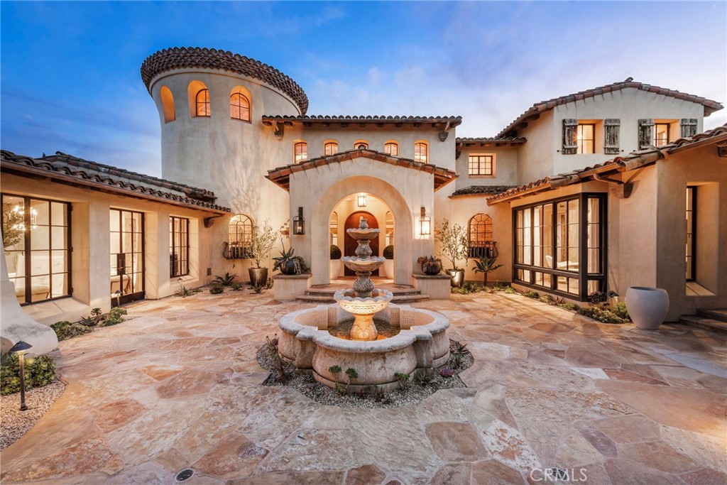 Ideally situated on a premium view lot in the exclusive guard gated community of Shady Canyon, 31 Blue Heron offers views of the rolling hills and dramatic sunsets while offering exceptional design elements that will truly impress design aficionados and the most discerning buyers alike. This stunning custom estate is adorned with steel and glass doors & windows, hand-crafted reclaimed beams, artisan brick walls, Obeche wood cabinetry and paneling, and a mixture of exquisite limestone and wide-plank oak floors just to name a few design elements. The master crafted estate boasts 6 bedrooms, office, + 9 baths offering an elegantly appointed Main Floor Owners-Suite accompanied by a retreat + passthrough fireplace, spa like master bath showcasing artisan level Onyx slab stonework and bespoke millwork along with a "honeymooners grotto". The main floor also offers a designer kitchen with pro series appliances, wood and metal custom Obeche cabinetry, prep kitchen, and direct access to the atrium style breakfast nook and Great room creating a sense of openness and airiness where residents and guests can flow seamlessly between the indoor and outdoor spaces. In addition the main level offers a beautifully appointed formal living room, formal dining space w/ wine cellar and a main-floor secondary guest suite along with an office blooming with natural light and direct access to your private courtyard. Three additional bedroom suites & a loft are located on the upper level of this grand residence. The homes exceptional design continues down into the basement level featuring a oversized home gym w/ glass and mirrored walls, private "speak-easy" bar + second wine cellar along with the ultimate game & media room, a salon, guest suite, powder room, elevator which services all 3 floors, and access to your showcase garage with parking for 7-8 cars. The outdoor spaces in the residence have been professionally re-designed to create a resort like setting all while focusing in on creating the utmost privacy and tranquility. The detailed mosaic tile pool & spa are complimented by two outdoor loggias offering heated floors, an outdoor kitchen, fireplace, TV sitting area, bath, and outdoor shower. The triple gated property offers direct proximity to award winning Irvine schools, Shady Canyon Country Club featuring two world class Tom Fazio golf courses, and minutes away from Orange County's best dining, shopping, beaches and access to multiple nearby freeways.