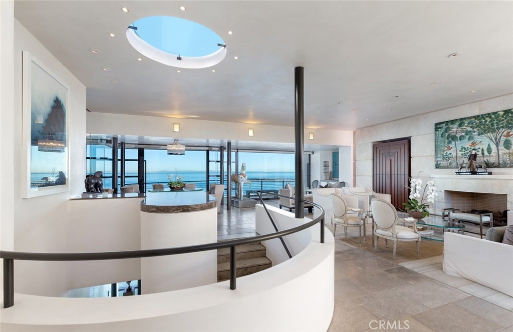 Superlatives fall short of describing the exquisite contemporary design of this newer oceanfront residence. The home is light, open, and takes in the unsurpassed views of whitewater, the harbor entrance, Catalina Island, and sunsets. A seven-year project, it was executed with care and consideration and built with the quality, precision, and detail of a fine sailing yacht. The main level is oriented around a generously-scaled great room that opens through retractable walls of glass - creating an even larger indoor/outdoor space. On one side it opens to an oceanfront terrace and on the other, to a secluded outdoor living room complemented by a fireplace and serving kitchen + bar. Inside, the main kitchen is detailed with imported Boffi cabinetry. The master level is a full-floor, two-bedroom suite w/ sitting area, fireplace, office, gym, and spacious bath + dressing. Completely private yet open to the dramatic views, it is the perfect private owner’s retreat. The ocean level has two bedroom suites and an entertaining space including a theater, sitting area, billiards + bar, kitchen, and an oceanfront terrace + spa. An impressive selection of materials was used including Venetian plaster; imported marbles; custom steel and bronze; inlaid matte lacquered doors; Wenge cabinetry and built-ins; and hand-cut limestone walls. A commercial elevator services all 3 floors. Accessible to the beach and village, with its quaint shopping and fine dining, this is the ultimate seaside home.