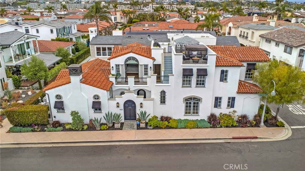 Uncover a treasure on Lido Isle! This exquisitely crafted custom home, basking in sunlight on a prime, eastern-end, corner lot, is just steps from Lido’s exclusive beach and clubhouse, epitomizing the relaxed, coastal lifestyle for which this renowned community is celebrated. The thoughtfully designed residence, with an appealing coastal flair, boasts 4 spacious ensuite bedrooms, including an elegant primary suite and a total of 4.5 baths. A media room/den provides the perfect retreat for family relaxation. The home features distressed French White Oak hardwood floors, beautiful stone counters, an abundance of windows and designer appointments throughout. The gourmet kitchen is outfitted with Viking appliances, a center island with sink, luxurious granite and marble countertops, abundant storage, and bar seating. The kitchen opens seamlessly into a spacious living and dining area, adjacent to an outdoor, charming, private strada patio framed by elegant French doors. Lushly landscaped, sunlight floods the home thanks to its southern exposure. Accessibility is enhanced with a first-level bedroom suite and an elevator. The expansive rooftop is perfect for entertaining or enjoying a sunset, complete with a lounging area, built-in BBQ, and Jacuzzi, ideal for savoring ocean, harbor, and city views while enjoying stunning sunsets with your favorite drink in hand. Additional amenities include a media room, laundry room, central air conditioning, a comprehensive security system with CCTV, and a central vacuum system. This coastal transitional home blends modern design with warm, inviting elements. Just a short stroll to Lido's best amenities and the vibrant Lido Marina Village, with its array of shops and dining options, this exceptional home offers an unmatched island lifestyle. The property can be purchased furnished and accessorized (outside of escrow)