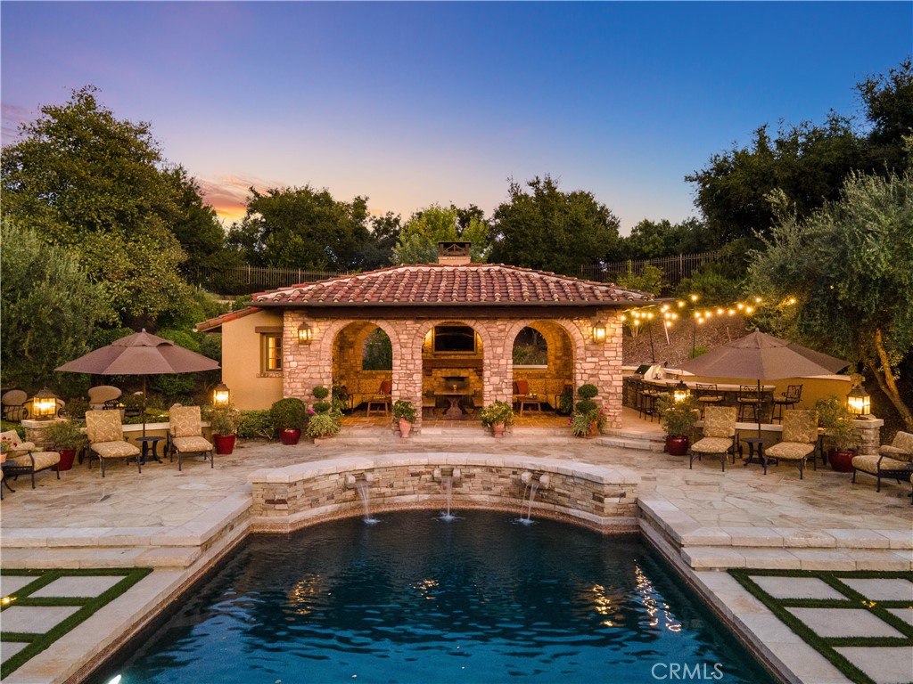 Casa della Grazia, a Tuscan-inspired masterpiece in the prestigious guard-gated Estates of The Oaks in Calabasas—the pinnacle of luxury living in Los Angeles. This custom estate, located on a serene cul-de-sac, spans nearly 10,000 square feet on 1.14 acres of lush, usable land. Featuring 6 bedrooms and 8.5 baths, it is designed for ultimate privacy and comfort, showcasing exquisite stone walls, soaring wood-beamed ceilings, and imported terra cotta tile flooring from France. Among the estate's many features is a newly updated, state-of-the-art movie theater, equipped with the latest technology for an unparalleled cinematic experience. The home also offers an elegant library with two-story ceilings, an oversized gym, a massive bonus/game room, and a private guest wing with a bedroom, full bath, and living room. The gourmet kitchen, complete with top-of-the-line appliances, flows seamlessly into the family room, ideal for entertaining. Additionally, the estate is equipped with a cutting-edge Savant home automation system, providing seamless control of the audio/video systems in the family room, game room, movie theater, and pool house. With built-in control pads, iPads, and remote access via smartphone, convenience is always at your fingertips. The system also includes a karaoke setup in the family room, game room, and pool house, along with an audio system that spans 11 zones—6 indoors and 5 outdoors—creating the perfect atmosphere throughout the home. The newly remodeled resort-style grounds feature a custom Pebble Tec pool and spa, Sport court, expansive stone patios, manicured lawns, an outdoor kitchen and BBQ center, and a stunning covered cabana with a fireplace and ¾ bath. The estate also boasts His and Hers garages for ultimate convenience.This extraordinary 6-bedroom, 8.5-bath property is filled with high-end designer finishes and unique character at every turn. An absolute must-see for those seeking unmatched elegance and exclusivity in Calabasas.
