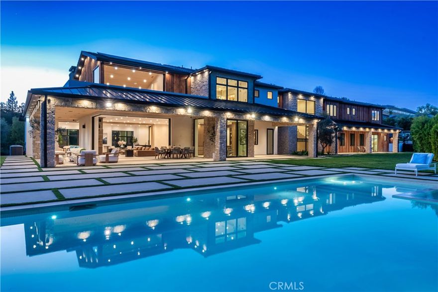 The absolute premier trophy estate in guard gated Hidden Hills! An awe inspiring brand new contemporary Napa Ranch masterpiece designed and built to perfection! Ideally set on 1.86 acres with complete privacy and mountain views! Spanning over 14,000 square feet, this one of a kind custom boasts every amenity desired and expected for a home of this caliber. Features include a state of the art 20 person theater, epic office/library, 6 en-suite bedrooms, 9 baths and much more. The dream center island kitchen opens seamlessly to the massive great room and lounge  which is graced with multiple sets of pocket doors, floor to ceiling stone fireplace, wet bar and temperature controlled wine walls creating a sensational space for indoor/outdoor entertaining. There is an ELEVATOR connecting all three levels. The lower level is something special. There is a bonus/game room and a world class gym/wellness center with separate steam room and saunas.  Accessing the space is a spectacular 12+ car finished garage ideal for the most discerning automotive collector. There are two secondary en-suite bedrooms on the main level leaving the upstairs with three large bedroom suites and a primary that will leave you speechless. The primary opens to a oversized viewing balcony and is enhanced with a kitchenette, soaring cathedral ceilings, fireplace and a Four seasons quality bathroom that is second to none. The resort style grounds provide a custom pool and spa, multiple covered patios, outdoor kitchen, pickle ball court, barn and massive manicured lawns all with total complete privacy. Other amenities include a main level everyday garage, smart home system, security cameras and too much more to mention. This is one of the trophy estates in Southern California's premier guard gated equestrian communities. A very special offering