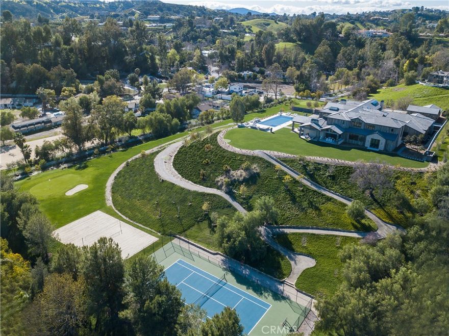 Brand new, spectacular, one of a kind estate sited on 7.4 lushly landscaped acres highlighted by panoramic views. Enter through private gates, cross the storybook bridge, pass the picturesque barn, and take the gently winding driveway to the top where you'll be welcomed by this magnificent estate. Step through the custom iron & glass door into a 24' tall entry, where 14,491 square feet of superb quality and refined elegance awaits. Highlights include a state of the art chef's kitchen that flows into the great room with open beam ceiling, fireplace and sliding walls of glass that open to the adjoining outdoor living room, a formal dining room with adjacent Onyx wet bar and glass encased wine display, luxurious home theater with upholstered walls, large game room with bar and snack center, glass surrounded gym with steam shower, private study, sunny bonus room, and 6 en suite bedrooms, including the spectacular master suite with dual, all stone baths, walk-out view balcony, and enormous wardrobe closets. The showplace grounds feature an approx. 65' long zero edge pool & spa, two complete barbecue centers, two 3-par golf holes, a championship tennis court, sand volleyball court, over 1/2 mile of private golf cart trails, 1,836' of covered patios, 1,600' barn, two fire pits, multiple entertaining areas, and garages for 11 cars. Additional amenities include European Oak floors, decorator lighting fixtures, elevator, Savant smart home system with Lutron lighting, fountains & more.