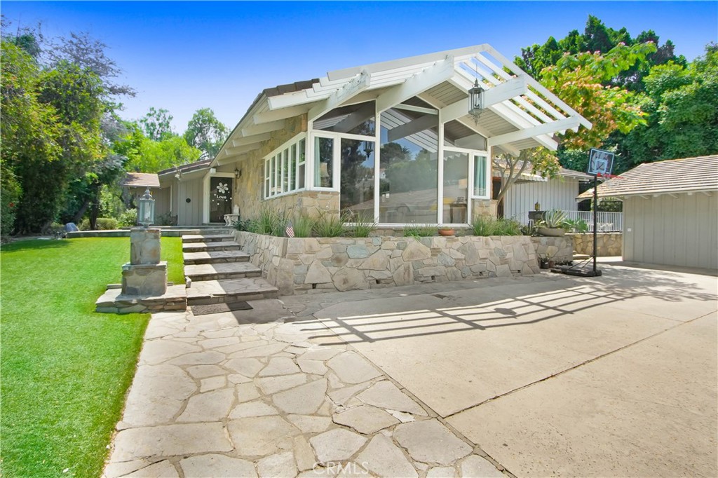 Stunning gated estate is nestled in 5.56 acres of rolling Covina Hills, boasting breathtaking views of the valley and city lights. A private winding driveway leads directly to the main house. The main house features a spacious living room with a magnificent fireplace and vaulted window-wall showcasing the panoramic views. The total living area spans 4,404 square feet consist of main house (3,500sf), a charming tea house (288sf), and a comfortable guest house (616sf). Additionally, the property is complimented with a permitted 800sf barn and a detached 3-car garage. The backyard is an oasis, complete with a large private pool, inviting cabanas, stone patios, a tranquil koi pond, and serene walking trails. The kitchen is equipped with granite countertops, high-end appliances, and elegant marble flooring. Each bedroom boasts its own ensuite bathroom, and the cabinetry throughout the house is exquisitely crafted. Furthermore, there is a 4-stall barn at the bottom of hill away from main house with a tack room and feed storage.