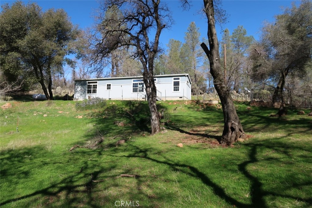 WOW! CHECK THIS PRICE. LOOKING FOR PEACE AND QUIET, with a view of the Sutter Buttes and the Valley? This HUD home will be sure to delight. Located in the rolling foothills of Oroville, this newer manufactured home has everything you could need to have the privacy you've been searching for, on 8.23 acres of land! Two bedrooms, two bathrooms, attractive dark cherry-look cabinets. Seasonal creek with a pond on this land! Tankless water heater, Generac generator- this home is ready to go. There is also a shop building, fenced goat yard and chicken coop- live off the land. Horses or livestock? Lots of room! Call for more information or to arrange private showing.