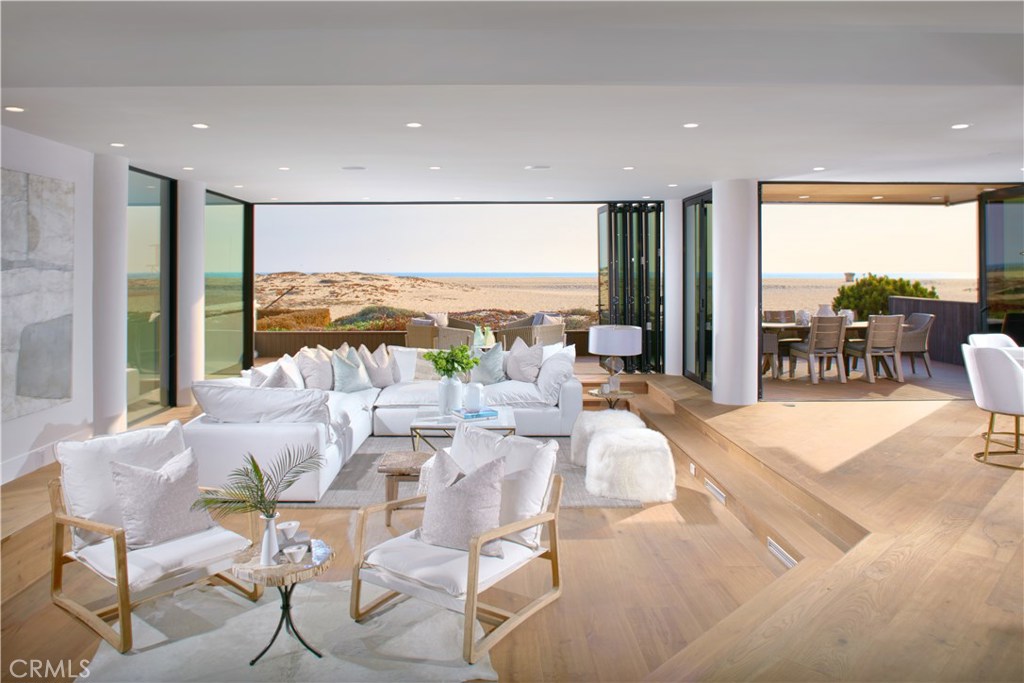 Exhilarating views of “The Wedge”, ocean, Catalina, and sunsets abound from this James Kincannon estate completely reimagined with a coastal contemporary design by celebrated designer, Becki Owens. Situated at the sand’s edge with approximately 40 feet of frontage and no pedestrian boardwalk to compromise its views or privacy, the home leans into its open-concept layout with floor-to-ceiling Western accordion doors systems that effortlessly blend the luxe interior and patio living. Upon arrival, a refreshed façade introduces the light and bright aesthetic with smooth stucco exterior, hardwood flooring and a custom garage door. Bespoke appointments are evident throughout the 3-bedroom, 3.5-bathroom residence including a mix of black, bronze and brass fixtures. A gourmet kitchen with slab waterfall countertops and premium appliances overlooks the main level common areas while flowing into a formal dining area backed by the glistening sea. On the second level awaits all bedrooms, two of which are en suite. The master suite is a sight to behold with walls of glass overlooking the coast, private deck and spa-bath featuring book-matched slab marble shower and freestanding tub. Completing the residence are a beautifully appointed laundry room, a 360-degree-view rooftop deck, outdoor shower and a premier beach front location.