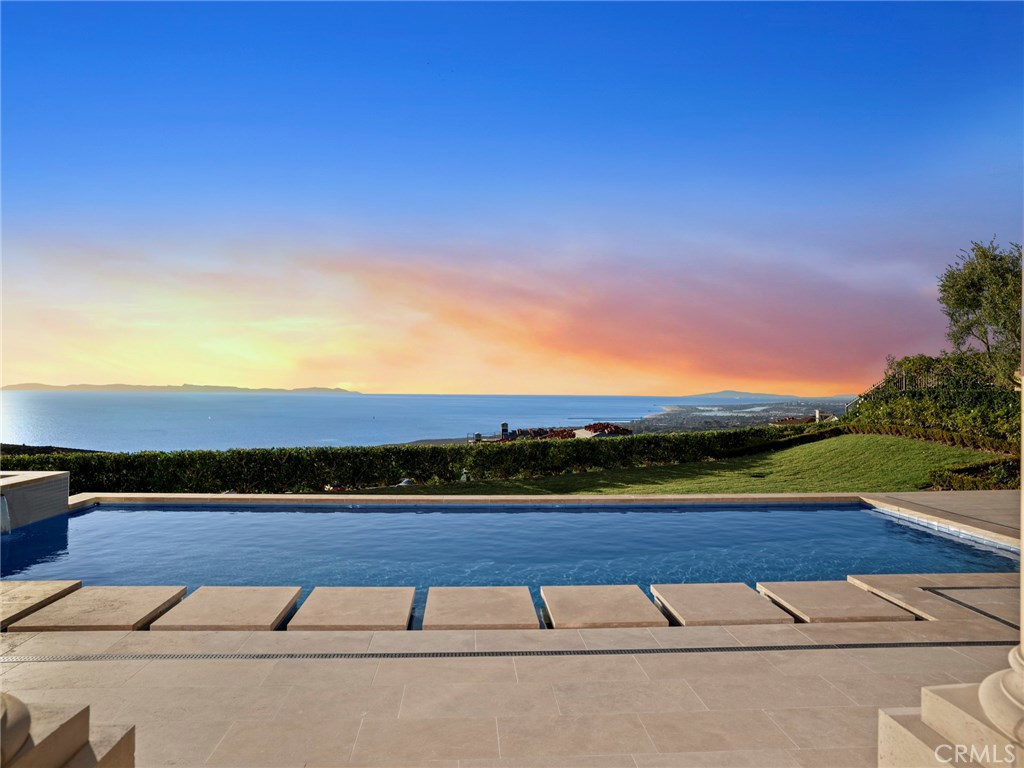 Among the finest trophy estates to be publicly offered in Orange County, 10 Coral Ridge is championed behind the world renowned gates of the Crystal Cove Custom Home Sites. Ideally situated to optimize the unparalleled views of the Pacific Ocean’s sparkling waters, Catalina Island’s rolling cliff-sides, and the coastline’s glistening lights, nearly every room in the home enjoys this glorious scenery. A creative collaboration between the world-class visionaries at EBTA Architects and the master craftsmen at Haigh Builders, the home offers a transitional, bright living space, made possible by the rare 35 foot building envelope. The main level delivers a magnificent first impression thanks to soaring ceilings, a spacious guest suite and a wood-paneled executive office. A gourmet chef’s kitchen, highlighted by two sizable islands, pro-grade appliances, & butler’s pantry, lies adjacent to the family room, which is complemented by delicately coffered ceilings, limestone flooring, and an abundance of natural light. Electronic pocketing doors along the back of the home weave the indoor & outdoor spaces into one, providing ample space for lavish celebrations while maintaining warmth and practicality for everyday living. The grand master bedroom boasts his & baths featuring spa like amenities & dual closets. The lower level offers a game-room, move theater, billiards room, bar area, wine cellar, & gym. The resort style backyard is highlighted by a pool, spa, & two ocean view loggias.