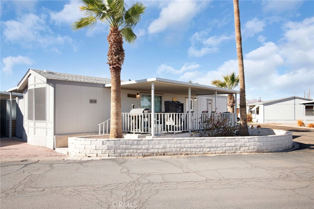 Looking for your place at the river? Here is the most adorable home located in the Needles Marina Resort Mobile Home Park. Needles Marina Resort includes riverfront beaches, launch ramp, store and a pool on site. Walk into this adorable home and you are going to love the upgrades and at home feel. Wood laminate flooring that is also water proof makes this home feel modern and makes the area feel spacious and its easy to clean. Granite counters in the kitchen with white cabinets and a large pantry for extra storage. Living room has tons of natural light with the glass slider that opens up to the front covered patio which you will love to enjoy on those summer nights. Home has indoor laundry and the bedrooms are big enough to fit bunk beds and a king sized bed. Now the covered patio/carport that is the length of the home which can fit a truck, golf cart, boat and more. Also this home comes with the storage unit/pod, the furniture inside can go with the sale. Seller has done ton of upgrades including new ac unit, newer water heater (3 years old), and Awnings are approx 2 years old. Come take a look and make this your river home before its sold.