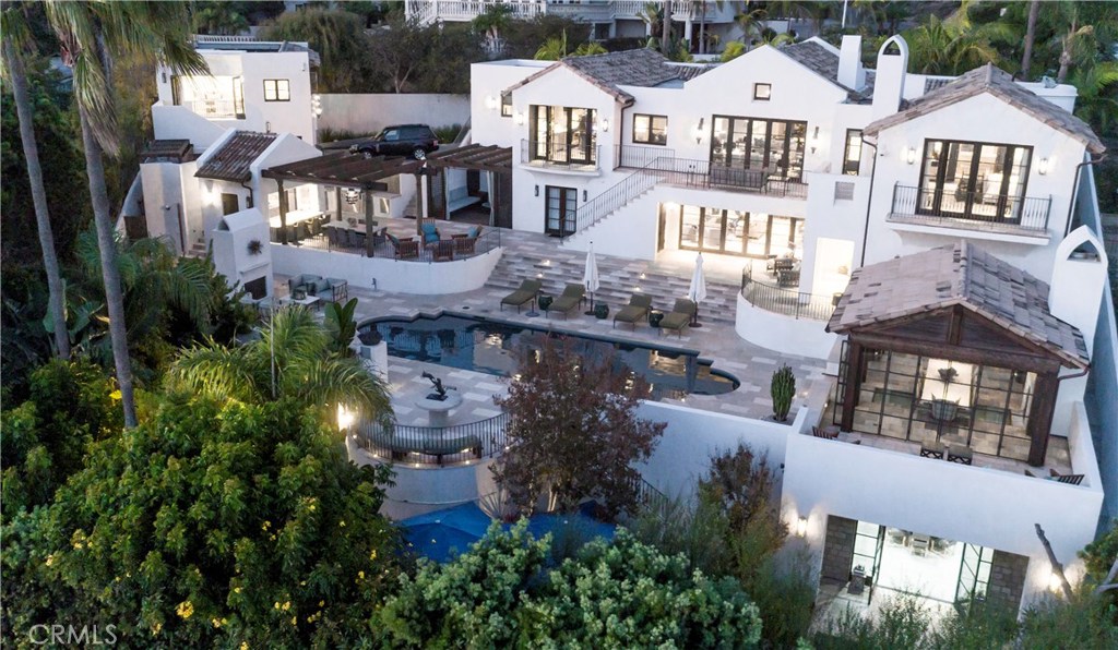 Located at the peak of the prestigious Hill Section of Hermosa Beach, blocks from the Pacific Ocean, this four-bedroom, six-bathroom estate was meticulously built with a balanced combination of architecture, design and timeless finishes. A dramatic entry with soaring ceilings leads through the main level, which features a formal dining room, living room, kitchen and service kitchen with state-of-the-art appliances. The spacious open floor plan is designed for entertaining. The detached wine cellar holds 1,000 bottles of wine and sits underneath a pavilion area with a gas fireplace and outdoor dining that offers a serene retreat. Featuring panoramic ocean views, the second floor offers an open floor plan with three spacious bedrooms, an office, a bar and a beautiful wine cellar that holds 1,500 bottles. The detached guest suite with a full kitchen and bathroom offers a private deck overlooking the pool and breathtaking ocean views. For the luxury connoisseur, the property offers a garage with a lift system that can store up to five cars in total. This is an amazing opportunity to entertain, play and live the Southern California lifestyle.