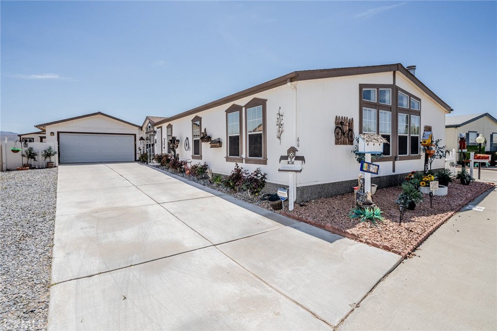 Welcome to 22241 Nisqually Rd #66, located in the highly desirable Vista Del Rosa, a premier 55+ gated community in Apple Valley. The park is professional managed with excellent onsite management. This spacious and beautifully designed home is the perfect blend of comfort, convenience, and style—ideal for those looking for a serene, active lifestyle in a welcoming environment. As you drive up the long driveway and approach the front door, you’ll be greeted by the inviting charm of this beautiful home. Once inside, you’ll appreciate the wide hallway and open floor plan, which provides ease of mobility and a sense of spaciousness. Large windows throughout fill the home with natural light, creating a warm and airy atmosphere. The stunning wood-look floors add a touch of elegance and complement the home’s design. The dining area flows into the kitchen, creating an ideal space for entertaining family and friends. The kitchen is a chef’s dream with a large island providing extra counter space, stainless steel sink, gas stove with built-in microwave, and a walk-in pantry for ample storage. A skylight above adds a touch of natural light. The split bedroom design offers privacy for both residents and guests. The spacious primary bedroom features an en-suite bathroom with a soaking tub, step-in shower, linen closet, reach-in closet, and a bidet toilet for added comfort and convenience. The oversized family room is a true highlight, boasting more large windows that bring in the light and a cozy fireplace perfect for relaxing evenings. Ceiling fans further enhance the room’s warmth and charm, making it a wonderful space for gathering with loved ones. This family room can also be used as a home office, craft room or fifth bedroom. Vista Del Rosa is a pet friendly, well maintained park and offers fantastic amenities for an active lifestyle, including a sparkling pool, soothing Jacuzzi, lighted tennis courts, dog park, clubhouse with kitchen, billiard room, and craft room. There are plenty of social activities to enjoy too. Close to shopping, dining, and local attractions. Whether you’re relaxing at home or enjoying all the wonderful amenities, this is a place where you’ll feel right at home. Don’t miss out on the opportunity to make this beautiful home yours—schedule a private tour today and experience the lifestyle and community at Vista Del Rosa!