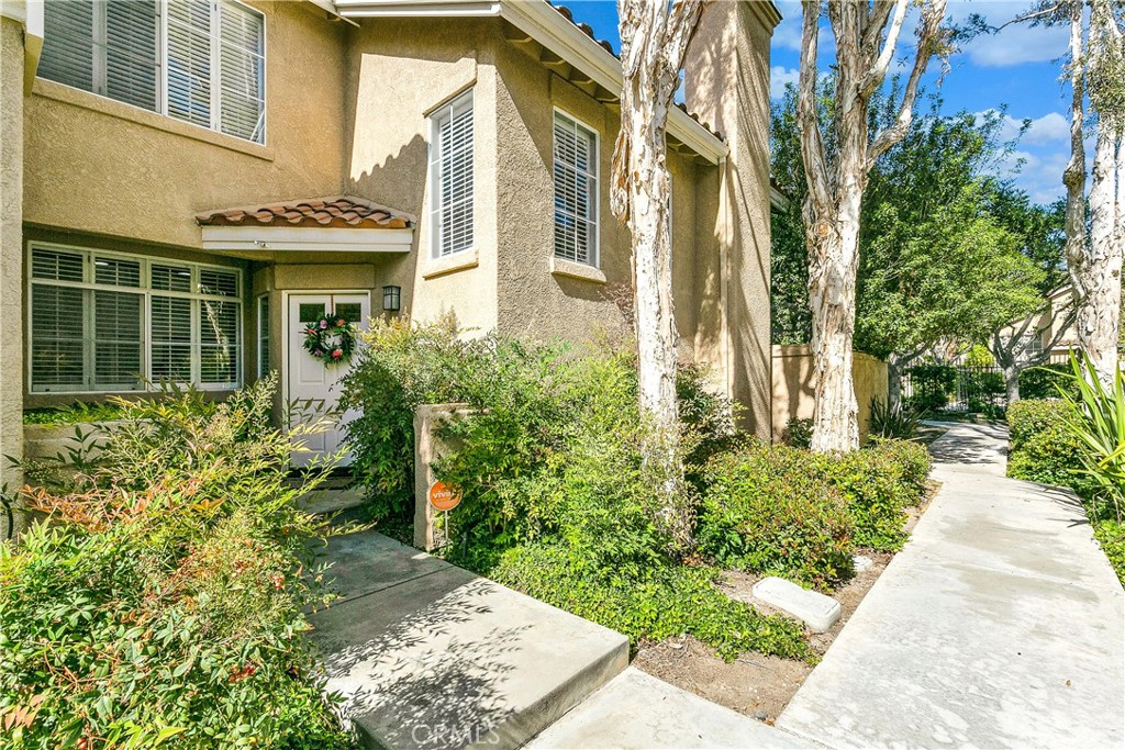 Enjoy resort-style living year round in this beautiful Monte Vista townhome located in desirable Santiago Hills. As you enter then home you are greeted by an abundance of natural light and cathedral ceilings. The floorplan provides kitchen with built-in pantry and custom cabinetry, dining area, highly sought-after downstairs bedroom and bath, and living room with fireplace and double doors to patio. Relax and enjoy outdoor living on the spacious covered patio that backs to tree lined path. Home appointments include hardwood flooring, ceiling fans, upgraded baths and so much more. Direct access to the garage with lots of extra room for storage. The community is walking distance to Regional Parks, Peters Canyon hiking trail, coffee shops, dining, shopping, Award Winning Chapman Hills Elementary, and Santiago Canyon College. wonderful location within the community allows close access to the community amenities include sparkling pool and spa.