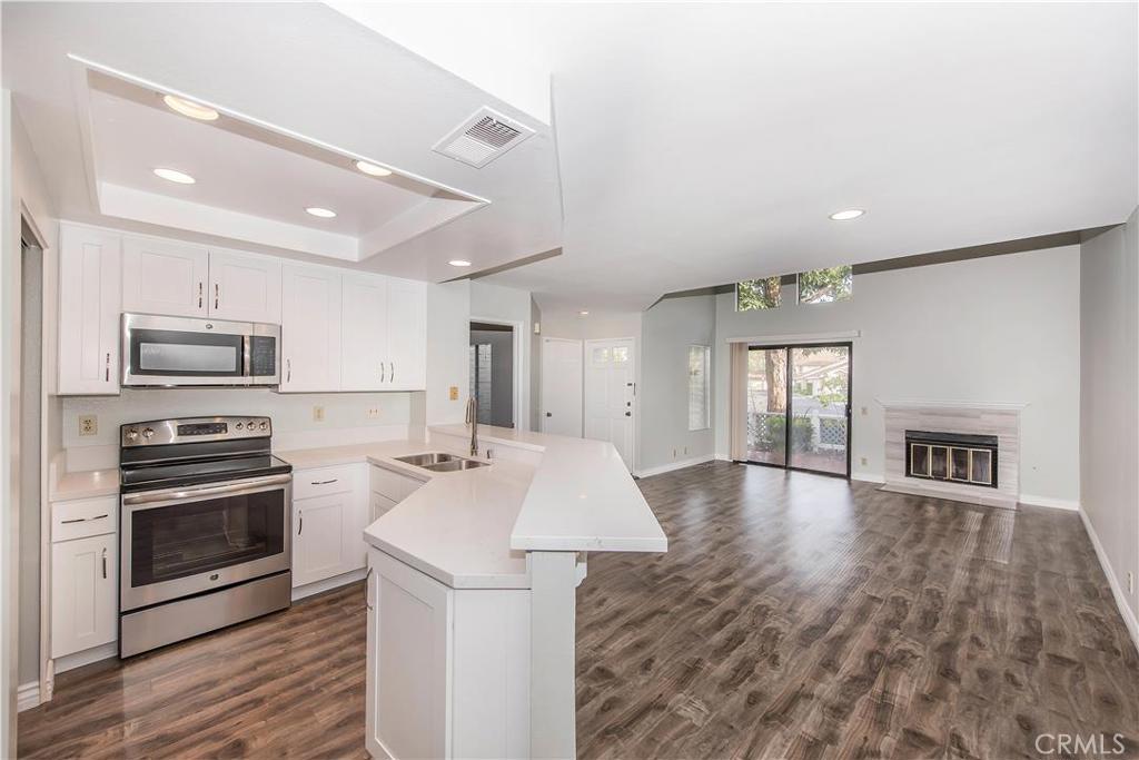 Be the first ones to live in this totally renovated from top to bottom two bedrooms two bath condominium with newer appliances. The downstairs master bedroom features UPGRADED spacious shower, dual vanities, stunning mirrors, and hardware. The kitchen sparkles with WHITE GRANITE/QUARTZ countertops with a 6-inch backsplash look incredible with the upgraded stainless steel appliances. The extended kitchen counter is perfect for casual eating on barstools. The kitchen looks onto the OPEN FLOOR-PLAN living and dining area. You’ll appreciate the new tiles on the fireplace. Soft gray designer paints colors throughout the condo. New wood laminate flooring downstairs and new carpet on the stairs and in the upstairs bedroom and new baseboards throughout. The unit also comes with newer washer, dryer, and refrigerator. ONE CAR SHARED DETACHED GARAGE. The home is located on a tree-lined pathway and is a very short walk to a popular Woodbridge pool & spa. Woodbridge has been heralded the safest city in the nation within the exemplary IRVINE SCHOOL system. Woodbridge is an excellent, amazing place to live with 2 lakes, 22 pools, 44 parks and more. The home is close to great shopping and restaurants and is freeway-close.
