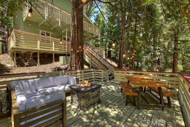 This is the perfect getaway from it all! Perched high up in the trees, this lovely mountain cabin has a sense of seclusion and tranquility. As you walk up to the home, there is a welcoming entertainer's deck - perfect for summer evenings to enjoy the outdoors. A few steps up, and you enter the home where you'll find the two bedrooms on the lower level. Upstairs is the main living level, with an open concept, gas stove and vaulted ceilings. The full bathroom and well appointed kitchen is on this level. Laundry closet is in the kitchen. A back door leads to a concrete patio - more space for entertaining! And a slider off the living room leads to an upper deck, to enjoy the treehouse feel of this property. You will love the private setting of this home.