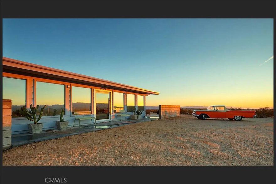 SKY RANCH SONORA: North Joshua Tree’s most sublime residence. Designed by renowned executive producer and visionary Chris Hanley, whose body-of-work over the last three decades has left an indelible imprint on modern culture – American Psycho & Spring Breakers to name two – in much the same manner that his more recent architectural visions in Joshua Tree have forever altered the Mojave Desert landscape. From The Invisible House to Sky Ranch Sonora and beyond emerge a modern urban design melding into the vast surrounding wilderness to create an unparalleled experience. Presently a permitted, high-grossing, year-round vacation rental, catering to the entertainment industry, the property can also be used as a private estate spread over 5 acres and fully-fenced for security. To the east stands government-owned land providing an additional privacy barrier. Custom pool, spa and sunbathing retreat positioned to gaze across undisturbed desert providing a true year-round indoor/outdoor environment. Wrap around patio perfect for yoga or retreats. Large enclosed private porch on the northside can be used variously as either office headquarters, a winter yoga room or an art, music or writing studio. Turnkey, fully-furnished, including a large collection of collectable original artwork featuring many films and more. In addition, the home is finished with state-of-the-art appliances, including a Nobilia/Leitch German kitchen, complete with Miele cooktop/oven and Bosch refrigerator and dishwasher. Bathrooms feature Duravit. Multi-zone Sonos audio throughout home and outdoors. Tall ceilings and open space lend to the serene interior flow. New solar system for efficient energy usage. Rare sprawling desert compound can accommodate family, guests or entourage. Professionally managed with multiple possible income streams; management can remain in place to facilitate immediate income. One of Joshua Tree’s most desired estates that has remained hidden from the mainstream now available for private viewings.