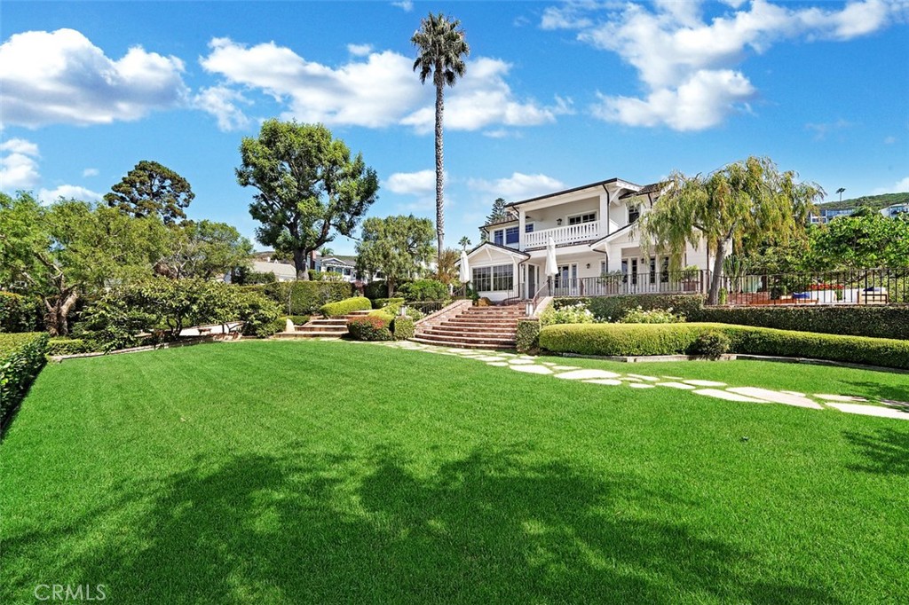 Experience a slice of California history at 451 Hawthorne Road, a stunning 1921 Craftsman home, beautifully restored by the current owners nestled in the heart of Laguna Beach. This rare architectural treasure unfolds across a 17,762 sq foot private lot of coveted North Laguna real estate, boasting 5 bedrooms and 4.5 baths - a perfect blend of century-old craftsmanship and modern luxury.
The estate-like grounds feature a lush lawn, garden pavilion, oversized private pool, mature trees, and a variety of fruit trees creating a private oasis with ocean views. Inside, discover a gourmet kitchen with top-tier appliances, granite counters, and a bar counter that opens to a spacious dining room with three sets of French doors leading to the main patio and gardens. The main living room, graced with ocean views, features a cozy wood-burning fireplace, custom solid wood flooring, and open-beamed ceilings. The lower level includes a warm and inviting family room, three bedrooms, two full bathrooms, and a powder room. One main level bedroom serves as a self-contained guest house, complete with a new bathroom and small kitchen, accessible from both inside and outside the home. The upper level houses the primary bedroom suite impressing with a spacious sitting room, fireplace, high open-beamed ceilings, and access to an upper deck offering spectacular ocean views; the ultimate private sanctuary. The primary bathroom boasts an oversized shower and separate tub. Completing this sumptuous primary suite is a private office or massage room. Across the hallway a generous bedroom and bathroom complete the upper level.
Listed on the National Register of Historic Places, this property benefits from the Mills Act, a California state law that provides significant property tax reductions to owners who actively preserve historic buildings. This incentive not only ensures the conservation of architectural treasures but also offers substantial financial advantages to discerning buyers. With its oversized garage and onsite parking for 7 cars, 451 Hawthorne Rd isn't just a home; it's a living legacy of California's rich cultural tapestry, waiting for its next chapter to be written. This rare opportunity allows you to own a piece of Laguna Beach history, where every detail tells a story of creativity, independence, and timeless beauty.