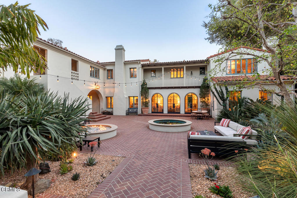 Quiet, privacy and peace are found in this elegant Roland Coate designed Monterey Colonial Revival estate built in 1928. Found on one of the most coveted streets in South Pasadena it is minutes by car to downtown LA & the Gold Line making it convenient to dining, shopping & entertainment. Meticulously maintained & upgraded over the years, it is an entertainer's delight! Built on more than an acre of beautifully landscaped grounds, this property strikes the unusual balance between the grandeur of an estate & the warmth of a comfortable, relaxing family home. The updated floor plan & modern amenities remain true to its historic architecture. The main house features four upstairs en-suite bedrooms with an additional bedroom on the main level, each tastefully designed with impeccable finishes. A sunny loggia connects the interior to the exterior with three sets of dramatic Palladian steel doors that open to the main courtyard with a fountain and oversized fire-pit making outdoor events year round a pleasure. A bluestone path lined with olive trees leads to an elegant pool and spa, a lighted north/south tennis court, bocce court, a batting cage and a stunning pool house. The pool house offers a covered pavilion with a fireplace, groin-vault ceiling & steel Palladian doors mirroring those in the loggia with a kitchenette, bathroom & a fully equipped barbeque/outdoor kitchen. Up a set of exterior stairs resides a separate guest quarters which includes a bedroom, bathroom & a gym.