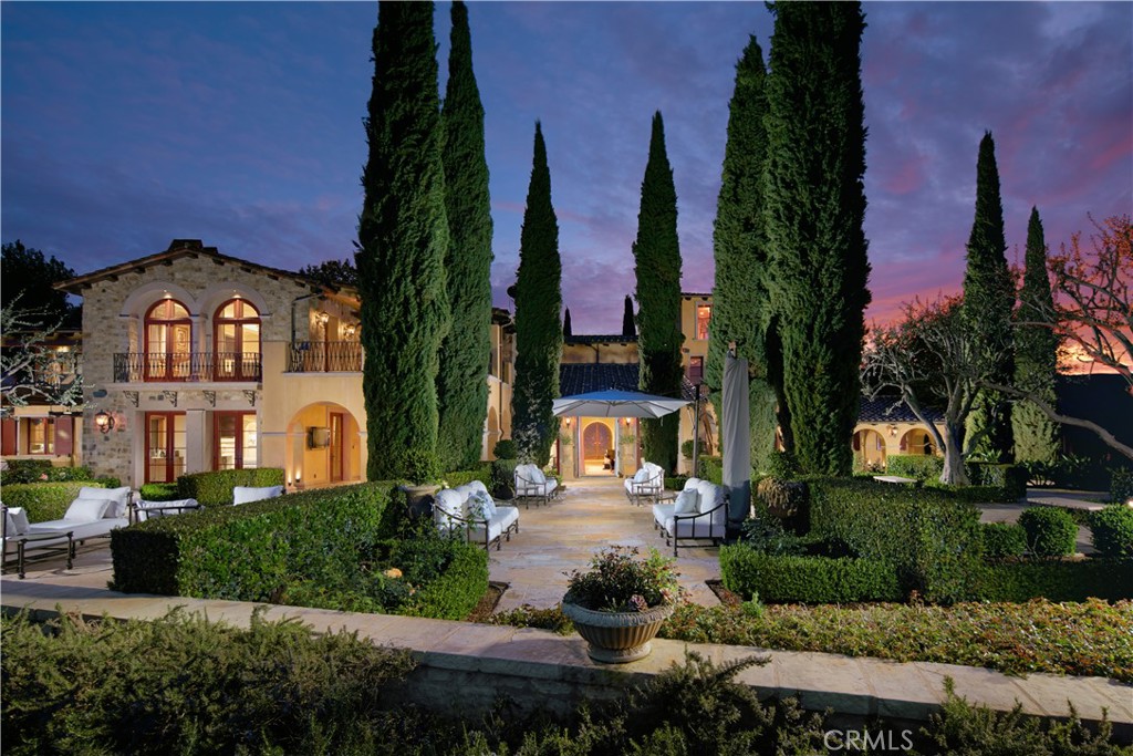 As the guarded gates of Irvine’s exclusive Shady Canyon silently close behind you, a sense of calm takes hold on the approach home to 60 Golden Eagle, a phenomenal custom estate without compare in Orange County. Private gates introduce the 1.42-acre property, which welcomes spectacular unobstructed golf course, evening-light and hill views. Enjoy ample privacy and extensive space for a front courtyard, a reflecting pool, limestone terraces, large rolling lawns, open seating areas, a grand scale open-air fireplace, a motorcourt for guest parking, meandering walkways, and lush and mature landscaping including olive, Italian cypress and oak trees. An indoor pool and spa pavilion is ideal for year-round entertaining and boasts a pool with custom mosaic design. Equally impressive, the residence’s interior is refined with limestone flooring, Venetian plaster, gorgeous lighting, custom millwork, barrel and coffered ceilings, an elevator, custom-carved marble fireplaces, and extensive use of handcrafted stone, wood and metal. Approximately 15,088 square feet, the luxurious villa reveals seven ensuite bedrooms, eleven opulent baths, multiple indoor/outdoor areas for entertaining, a 15-seat theater, a wine room with storage for approximately 1,000 bottles, a tower library and garage parking for five. Welcoming to all, the magazine-worthy kitchen hosts a large island, maple cabinetry, an oversized pantry with custom pull-out shelving, a fully equipped butler’s pantry, a spacious breakfast nook that opens to the backyard and cooking pavilions, and high-end Sub-Zero and Viking appliances. The primary suite pampers with a fireplace, gilded custom casework, a marble steam shower, jetted tub, and a magnificent custom closet with enclosed cabinetry, glass doors and a large marble island. Spanning two levels, a handsome wood-paneled office suite opens to the terrace with a stairway to grounds below. Downstairs, in the subterranean level of the residence, awaits an ensuite bedroom, a separate entrance, a wet bar and a kitchenette. Behind the scenes, high-tech amenities include a DSC security system, a Lutron lighting system and Crestron home automation.