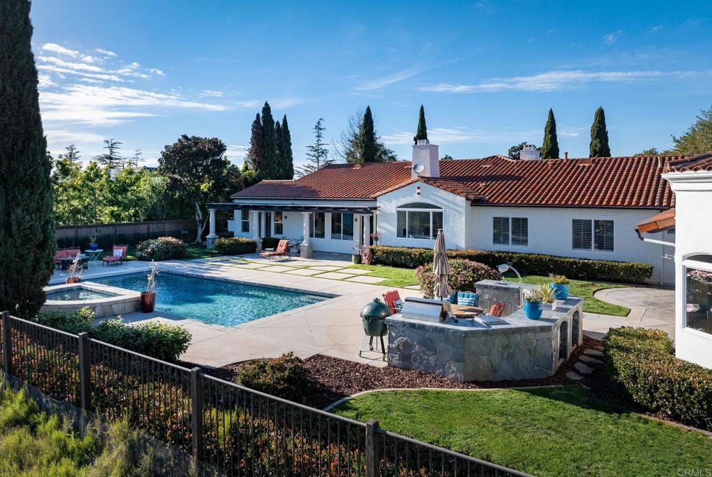 LOWEST PRICE/SF IN THE RANCH AT CARLSBAD! Introducing 7992 Paseo Esmerado, a captivating blend of charm and comfort nestled in Carlsbad, CA 92009. This sprawling single-story residence exudes a welcoming ambiance and is ideal for multi-generational living with its approximately 4750 sqft main house and 1400 sqft guest house. Situated on a serene .59-acre lot in the Ranch of Carlsbad, this hilltop home offers breathtaking southwest, canyon, and city light views. The California Hacienda style architecture, complete with charming shutters and a spacious entry courtyard, sets the stage for the inviting atmosphere within. The mostly one-level layout includes a 3-bedroom main house and a 2-bedroom guest house, both featuring en-suite bedrooms, master bedrooms with walk-in closets, full kitchens, and laundry facilities. The guest house, with its separate entry and no stairs, provides privacy and convenience for all occupants. Originally a Ranch at Carlsbad Plan 2, this home has been extensively customized and upgraded, with the square footage nearly doubled. The upgrades themselves would cost at least $2.5M+ in today’s environment. Privacy is paramount, with side trees and the home structure itself providing seclusion for the backyard and pool, ensuring neighbors cannot see in, even from their upper-level windows. A wall and locking privacy gate enhance privacy and security for the front courtyard. With 12 sets of French doors throughout, the home offers very private, secure, semi-outdoor living. Recently painted interiors and exteriors, along with new carpets, showcase the home's meticulous upkeep. Inside, 5 bedrooms and 7 baths ensure ample space for all. All appliances have been upgraded throughout, and all bathrooms boast upgrades. Step into the expansive living room, featuring high ceilings, built-ins, and a cozy fireplace, perfect for gathering with loved ones. The kitchen boasts abundant storage, triple Wolf ovens, a Wolf range, a large SubZero, a Bosch silent dishwasher, a built-in desk, and seating by the dual-sided fireplace, all while offering endless expansive views. Adjacent to the kitchen, the spacious dining room provides access to the wine cellar, extra space for seating by an additional fireplace, and access to the charming and private front courtyard with a fountain. Entertainment abounds with a sparkling pool, spa, and entertainment deck seamlessly integrated with the home, including a Wolf outdoor grill, separate burner, and outdoor sink. A massive shared access game room boasts a full bar with a SubZero refrigerator, SubZero ice maker, dishwasher, and beer taps. The game room has its own bathroom with separate outdoor access for the pool, along with semi-outdoor living space featuring heaters and a large wood-burning fireplace, all offering year-round enjoyment. The massive guest house kitchen features a Subzero refrigerator, dual “no stoop” dishwashers, oven, and range. Luxury touches abound, from high-end appliances to the custom 1000-bottle, temperature-controlled wine cellar, humidor, and tasting room. The music room, sizable enough for a baby grand piano, can also function as a home office, providing versatility to suit your lifestyle. French doors throughout facilitate indoor/outdoor living, while the 40-foot swimming pool with an automatic cover ensures convenience and safety. Personalized comfort is ensured with separate 4-zone heating and air conditioning zones for each area, while a 4-car attached garage caters to automotive enthusiasts. Nearby award-winning schools and access to miles of walking trails make this home not just a residence but a lifestyle choice. Experience the epitome of luxury living at 7992 Paseo Esmerado, where every detail has been thoughtfully curated for an unparalleled living experience in Carlsbad's most sought-after locale.