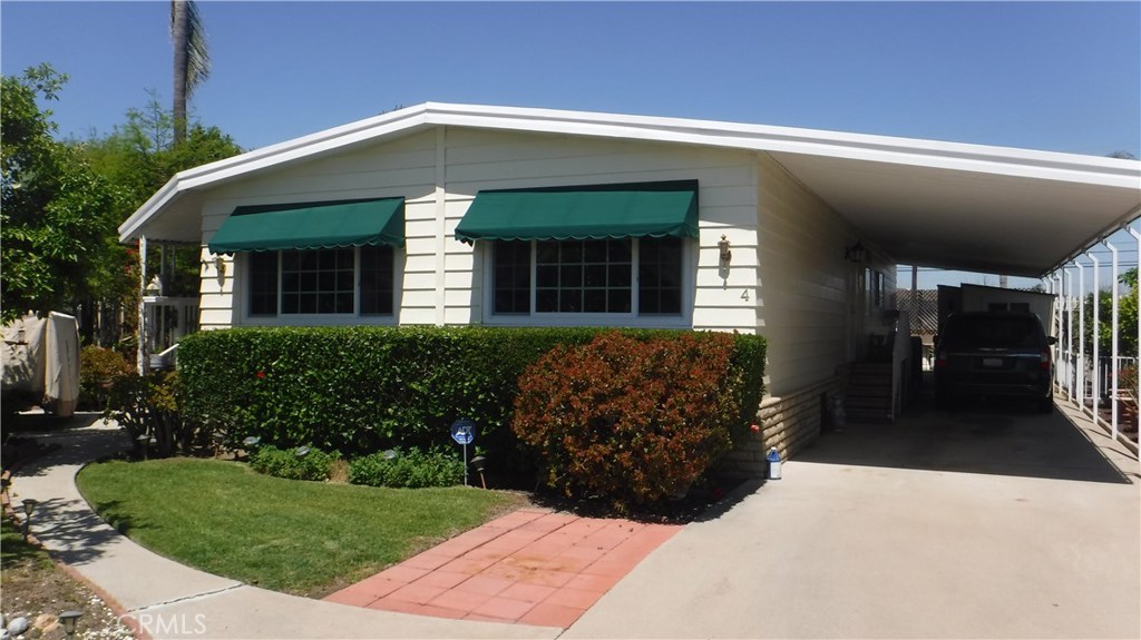 This lovely 2 Bedroom, 2 Bath mobile home with a large garden has a open living/dining area that boasts crown moldings, remote control blinds, oval glass wood entry door, carpet flooring, lighted built-in cabinet in the dining area. The newly remodeled kitchen shows white lacquered wood cabinets with slide out shelves, quartz counter tops, instant hot water heater in kitchen, dishwasher, garbage disposal, built-in microwave and electric oven, refrigerator/freezer, pantry and laminate flooring. Family room is off the kitchen with crown molding, built-in bookcase, wood/lead glass doors on bar with quartz countertop, plus 4 bar stools, laminate flooring and vinyl sliding french door to the porch. This Master bedroom is spacious with a professionally installed cedar lined closet. Master bath has newly installed walk-in glass shower doors, new counter tops, tile flooring and linen closet. 2nsd bath has walk-in shower as well. Enclosed patio room approximately 250 sq.ft. off family room has tile flooring and counter top desk for a computer work area and the rear door off the patio exits to the beautiful rear garden/yard. The yard has a Gazebo with concrete slab, plus water fountain, and the patio area has a Sun Setter awning to cool for hot summer days. This home has many extras; plus a new 120 sq.ft. wood shed in long driveway for 3 cars, A/C central/heating, water softer, all vinyl windows (except two windows) front and side awnings and security doors on on both sides.