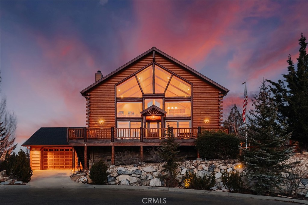 Imagine waking up to the sound of birds chirping, crisp mountain air, sparking lake, and surrounding mountain views! At the end of a peaceful cul-de-sac, with a huge back yard backing to the woods, this fully furnished, ready-to-enjoy retreat is a dream come true! Featuring an open floor plan with a 30-foot ceiling and wall of windows, this bright and spacious 4-bedroom, 3.5-bath log-style home is incredibly comfortably and accommodating, inviting year-round relaxation and adventure. The spacious main-level great room welcomes with soaring ceilings through to the loft, hearty hardwood floors, and an impressive stone fireplace. Ideal for entertaining, with a chef's kitchen including granite countertops, double oven, wine cooler, barstool seating, a cozy breakfast nook, and direct access to the back yard—complete with natural gas rock fire pit, a hot tub, natural gas BBQ, and abundant space for gatherings! Conveniently accessible from both the kitchen and main-level master suite, the expansive back deck overlooks the water, serene protected forest land, ensuring exceptional privacy. Upstairs, the large loft is equipped with a wet bar and mini-fridge, perfect for leisurely evenings or lively game nights around the pool table. The thoughtful layout includes two guest suites, and a devoted laundry room with wash sink and access to the garage. Extra benefits include A/C, lots of exterior lighting, low-maintenance-landscape, and freshly painted exterior and outside furniture - WOW!
