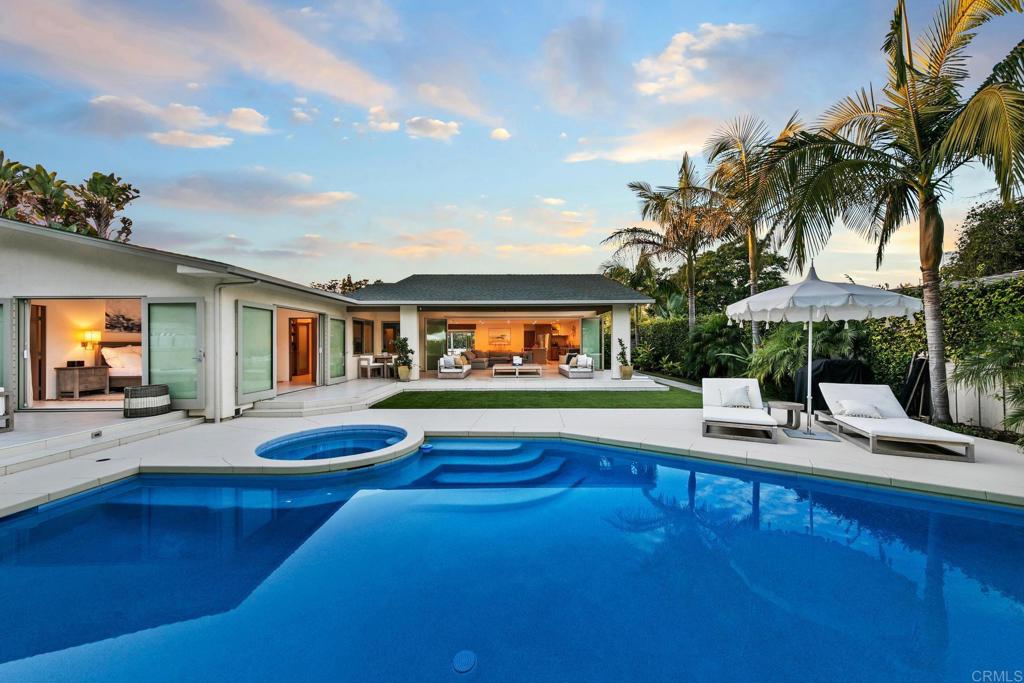 A single-level haven awaits in the heart of Coronado mere blocks from the beach in the prestigious Country Club Estates! Secluded on a generous 10,982 SF lot, warm modern vibes abound this thoughtful layout with an open floor plan and seamless integration of indoor / outdoor space. A Nana folding glass wall and oversized Western windows bring the outdoors in while flooding the home with natural light. Exposed wood, Viking appliances, warm wood cabinetry and Brazilian granite countertops, lend an air of luxury to this minimalists’ retreat. The sophisticated layout of three bedrooms, a dedicated office, and a den is complemented by an abundance of outdoor entertaining spaces in a resort like atmosphere where the solar heated pool and spa enjoy a verdant backdrop of trees and a captivating lighted water feature. The Viking kitchen becomes a focal point for culinary enthusiasts providing a functional space to entertain. Anchored by a center island, custom white oak cabinetry and warm Brazilian granite countertops provide storage and an undercounter microwave. A butler’s pantry, discreetly tucked away, serves as the perfect complement to the open living areas, offering convenience without compromising on the minimalist aesthetic. The master suite beckons relaxation, framed by two oversized French doors that gracefully open to the expansive rear of the property. A spacious soaking tub, glassed-in walk-in shower, and generously sized walk-in closet create the perfect place to unwind when the day is done. Not to be forgotten and creating a lasting first impression, the gated courtyard entry provides a private grassy enclave with gazing pond creating a uniquely calming atmosphere that sets the stage for what lies beyond. Lastly, plans exist for an expansion and renovation to create a two story 4,200esf 5BR / 4.5BA with an office, exercise room, and den. Renderings and floor plans available upon request.