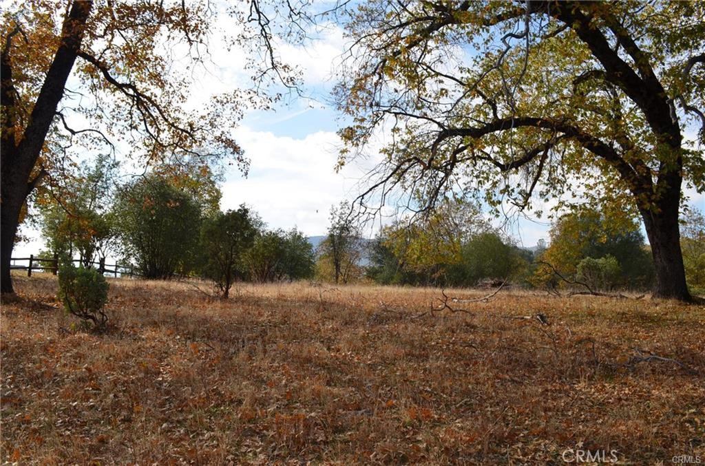 A very lovely, level 2.68 acre parcel in Sierra Highlands subdivision, between Oakhurst and North Fork, California. Numerous oak trees frame lovely views, with the potential for easily opening up even greater views. Close by is the south entrance to Yosemite National Park. This is on the community water system with power close by, and a fire hydrant around the corner. The owner would consider financing with substantial down payment. Take your time strolling around this beautiful spot! Just a few miles to Bass Lake and the end of cul de sac location make this a must-see!