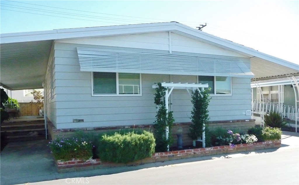 The first thing you will notice about this lovely home is the
well-landscaped lot, the large covered cement porch/entry steps and the smart-looking brick skirting and planter. Freshly painted inside. This pride of ownership home, with a unique floor plan, is looking for new owners. The home features two bedrooms, two bathrooms and a large hobby room with tons of storage, about 1,440 SF. Spacious living room with vaulted ceilings. Cozy dining room with built-in hutch. Circular eat-in kitchen has newer appliances. Refrigerator, washer and dryer included. Plush carpeting, tile and vinyl flooring. Master suite is in the back of the home and offers a good-sized closet, sunken tub and separate shower. Nice 2nd bedroom and guest bathroom on other side of home. Dual pane windows, Central Air Conditioning and under-awning storage shed for all your extras. Low-rise walk-up ramp and curved awning posts at driveway. This unique home is clean and neat....call now to see for yourself!!! Serial: PC1574A/B.