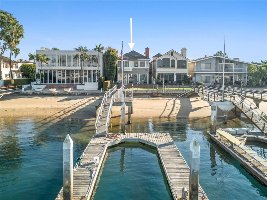 This grey-shingled, storied family home, located on a generous expanse of bayfront with its own dock, presents an opportunity to lay down roots in a prime lot on Peninsula Point. Offering 4 bedrooms & 3.5 baths in almost 3,000 square feet of living space, this residence is open, airy and full of charm – the perfect place to call home & plan your dream day on the bay or beach. Kick up your feet on your private dock & watch the boats cruise by, taking in scenic harbor views & the enchanting landscape beyond. Inside, a wide-open family room with original brick fireplace is the ideal spot for gathering; glass doors open onto the patio, grassy yard and beach. The white kitchen is replete with new stainless appliances and a charming corner breakfast nook, while a wet bar is tucked behind accordion doors. A large dining area, quaint powder room & guest suite with full bath & peaceful back patio complete the first floor. Upstairs you’ll find two sunlit bedrooms & a full bath as well as a convenient laundry room and Master Suite. Here, a wall of windows affords sweeping water views, while a fireplace keeps things cozy & a separate sitting area, walk-in closet & beachy Master bath complete the amenities. Cathedral ceilings, polished hardwood floors & original architectural detail contribute to the appeal of this traditional Cape Cod residence. Located along a highly coveted stretch of waterfront near the end of Peninsula Point, this property is a once-in-a-lifetime opportunity!