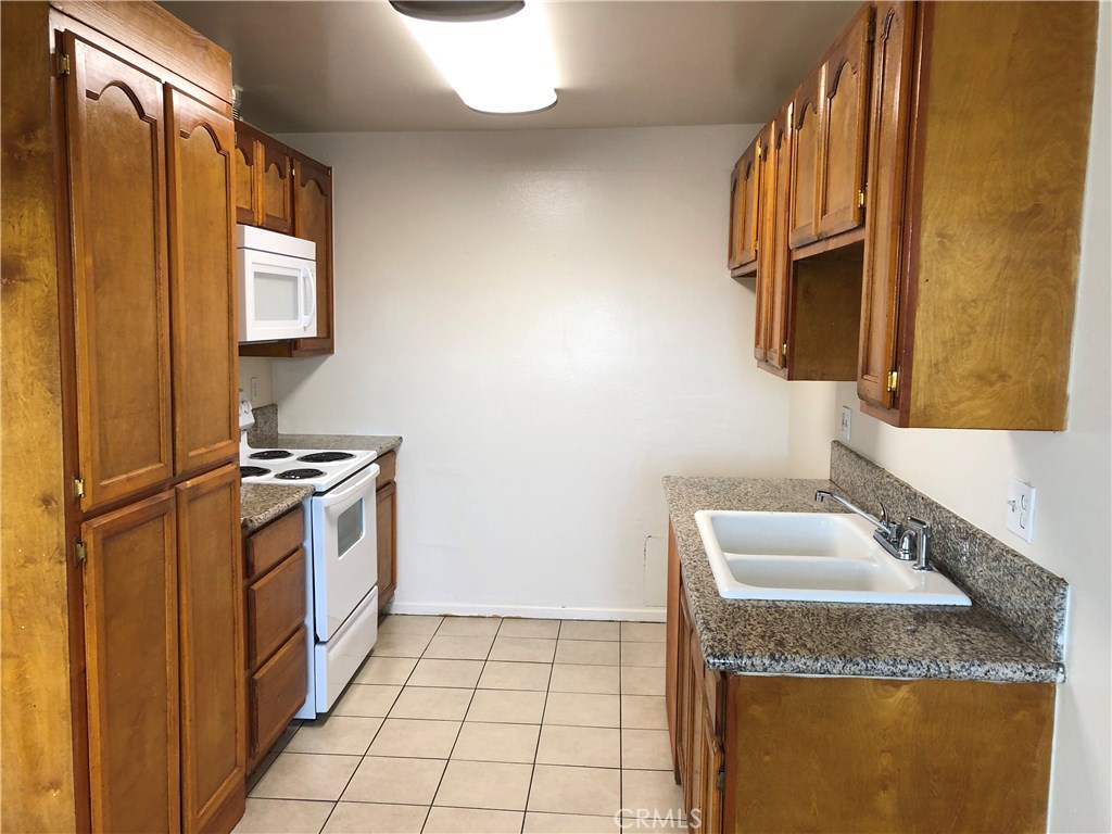 Located in Cinnamon Tree which is a secured gated condo complex. Close to freeways, shopping, park, library and minutes from California State University Fullerton. Newer double pane windows, microwave, paint. Granite counter in kitchen. Big master bedroom with dual mirrored closet. Second bedroom has walk-in closet. Wall air conditioner in living room. Separate storage room next to the front door. One assigned carport and one additional permitted perking in open parking areas. HOA fees include water trash and sewer. Has community pool and spa.