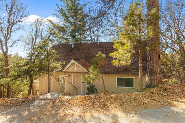 Cozy, modified A-frame Cabin in Arrowhead Woods! Beautiful vaulted ceilings, with floor to ceiling windows to bring in the natural light and serene mountain views that you can enjoy from the living room, kitchen, and dining area. Only a few steps to the front door, you walk in to the living room with the freestanding, wood burning stove, then around the staircase is the dining nook and kitchen. Laundry room with pantry off kitchen. The main floor also has 2 bedrooms and 1 bathroom with the 3rd bedroom and second bath upstairs. Great deck for entertaining. Situated on almost a quarter of an acre, this lake rights home is a must see!
