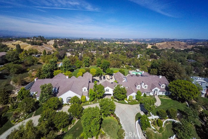 Extraordinary, one-of-a-kind, gated estate on 3+ acres with panoramic city lights views. Located in the prime Ashley Ridge section of Hidden Hills, this home features over 17,000 square feet of luxury living. The Classic Traditional main house is light & bright, and features large formal living & dining rooms, a gourmet kitchen that opens to the big family room, which adjoins the outdoor living room/veranda overlooking the sparkling pool, spa and endless views. Additional features include a beautiful master suite with sitting room, large closets, and private viewing terrace, 7 additional bedroom suites, and a paneled library. The entertainment wing includes a gorgeous movie theater, large lounge with professional wet bar, card/game area, gym/dance studio, recording studio, full guest suite, huge bonus room, and significant dressing room/closet wing. Other amenities include 8 fireplaces, garages for 8 cars, a large motor court with additional parking, children's play areas, rolling lawns, mature trees, great privacy, and direct access to hiking/equestrian trails. Model sharp and offering a rare combination of amenities, this home has it all. Showings to prequalified buyers only.