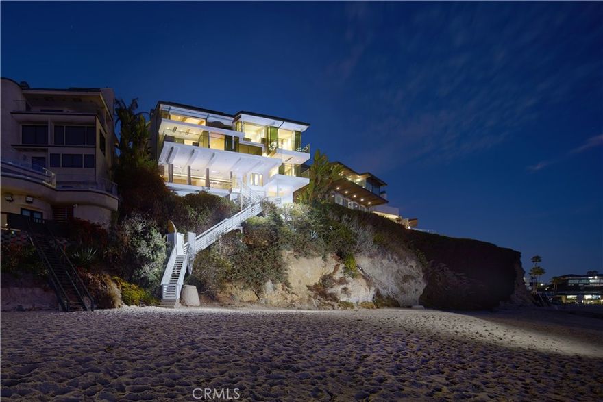 Perched above the sand on Laguna Beach’s most sought-after shoreline, this architectural masterpiece offers 79' of beach frontage with breathtaking panoramic ocean and coastline views. Painstakingly rebuilt by renowned interior design firm Aria Design and architect Anders Lasater, the beachfront residence boasts an unparalleled array of luxurious amenities including private steps descending to Laguna's highly coveted Victoria Beach. Spanning approximately 3,541 square feet across a split-level layout, the residence encompasses three bedrooms (including a tranquil meditation room), two offices, and three-and-one-half baths. At its heart lies a SieMatic kitchen—a chef’s dream outfitted with quartz countertops, and two sets of Gaggenau ovens, Sub-Zero refrigerators, and Miele dishwashers. A custom bar area with Sub-Zero fridge/freezer drawers enhances entertaining, while floor-to-ceiling glass Fleetwood doors showcase mesmerizing ocean views and bathe the home in natural light. Exceptional details include a glass-enclosed refrigerated wine display with storage for 216 bottles and Isokern fireplaces in the living room and primary suite. Approximately 1,200 square feet of outdoor decks and terraces include features such as Infratech ceiling heaters, an outdoor lounge with bar, a water element, living wall, and firepits, creating numerous peaceful verandas. The primary suite is a private haven complete with heated towel racks and exquisite finishes. Exterior highlights include limestone and porcelain details, a copper roof, and EnduroShield-treated glass railings. Expansive decks and terraces extend the living space outdoors, providing an idyllic setting for alfresco dining or moments of tranquility with the sound of the waves. Situated within the exclusive gated community of Lagunita, the home blends privacy with proximity to the renowned Montage Resort. Additional highlights include an elevator, Savant home automation, seller-owned solar, a two-car garage with vaulted ceilings, dual washer/dryer laundry setups, air and water purification systems, and advanced security. With direct private access to the sand, 14 Lagunita Drive is a true representation of elevated coastal living, offering a daily retreat from the ordinary.