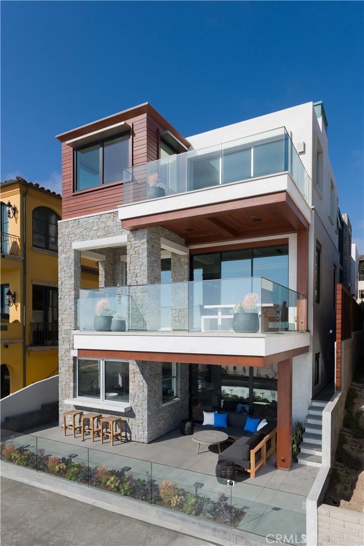 Built in 2016 this stunning Coastal Contemporary home is the newest & finest property available on the precious Manhattan Beach Strand. This chic 5,715 sf abode is designed with a modern floor plan featuring amazing ocean views & outdoor areas, 6 bedrooms, 7 bathrooms, 3 car garage, dedicated home theater & more. The striking exterior consists of Durable Materials including Limestone, African Mahogany, Anodized Aluminum, Copper & Stainless Steel. The interior is warm yet sleek & modern w/Brazilian Cherry hardwood floors, stone, Fleetwood doors & glass throughout. The 1st floor features a large rec room & bar flexible for a variety of uses w/Fleetwood doors leading to a patio & direct Strand access. Also on the 1st floor is the dedicated media room, 2 br’s, 2 ba’s & laundry room. Up the staircase is the 2nd level, also accessible through the 3 car garage or entry courtyard. The full body & inviting kitchen/great room area is fit with Double kitchen island, elevated bar seating, premier appliances, walk-in pantry w/extra fridge, great room & balcony w/stunning views and built in BBQ. Up the glass enclosed staircase to the top 3rd floor is the luxurious master suite + 3 en-suite bedrooms & 2nd laundry room. The master suite features stunning views, private balcony, office, his & hers walk in closets & luxurious bathroom. Other features include: 5 AC zones, elevator, Crestron Home Automation w/Lutron Shades, Vantage Lighting System & Automated security w/8 cameras.
