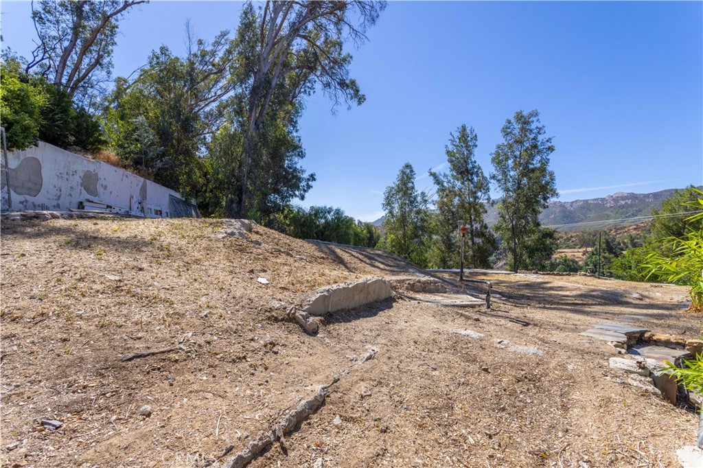 Rodeo Realty is proud to present Shangri-La in Agoura Hills! Don’t miss this opportunity to build your own cabin, artist studio or spiritual retreat on a one-of-a-kind nearly half acre lot. Immerse yourself in this idyllic mountain sanctuary year-round or for weekend getaways, where breathtaking sunrises and sunsets glimmer on the lake, decorate the mountains with ever-changing colors, and never disappoint. Discover a hidden paradise as you wander down the secluded multi-terraced gardens where indigenous flora adorns custom stone walls, ergonomically conscious stone stairways and paths. No expense was spared in the design, quality and craftsmanship of the custom outdoor enhancements that remain on this unique and distinctive property. One of the highlights of this secluded gem is a historically significant life-size three-tiered waterfall originally built as a movie set in the 1930’s. Imagine surrendering to the gentle sound of water flowing down the boulder falls in concert with the native birds, butterflies, and other wildlife. You will likely be greeted by the local parrots, herons and ospreys that live in harmony with the surrounding natural habitat. When you’re not creating, meditating, working, playing or simply “being” inside your living space-to-be, you'll be experiencing the magnetic vortex in the captivating gardens below. At the bottom of a non-creosote spiral wooden staircase, your own private dock awaits. As a member of the Malibou Lake Mountain Club, you have access to the lake, community pool, tennis court, clubhouse, and more. Located in the heart of our Southern California coastal range, Agoura Hills is the gateway to the Santa Monica Mountains, surrounded by thousands of protected and pristine acres of State Parkland and National Recreation Area, including Malibu Creek State Park, and Reagan and Paramount Ranches. Nature enthusiasts will love the endless hiking, equestrian trails and other outdoor activities, while animal lovers will appreciate the upcoming Wallis Annenberg Wildlife Crossing over the 101 Freeway for our protected Malibu Mountain Lions. A perfect location with convenient shopping including historic Whizin Market Square and everyone’s favorite Trader Joe’s nearby, plus dining, entertainment, culture, and more just minutes away. Enjoy a short scenic drive to Malibu and the Pacific Ocean, and get to the studios and LAX in less than an hour. Get ready for the enchantment and schedule your showing today!