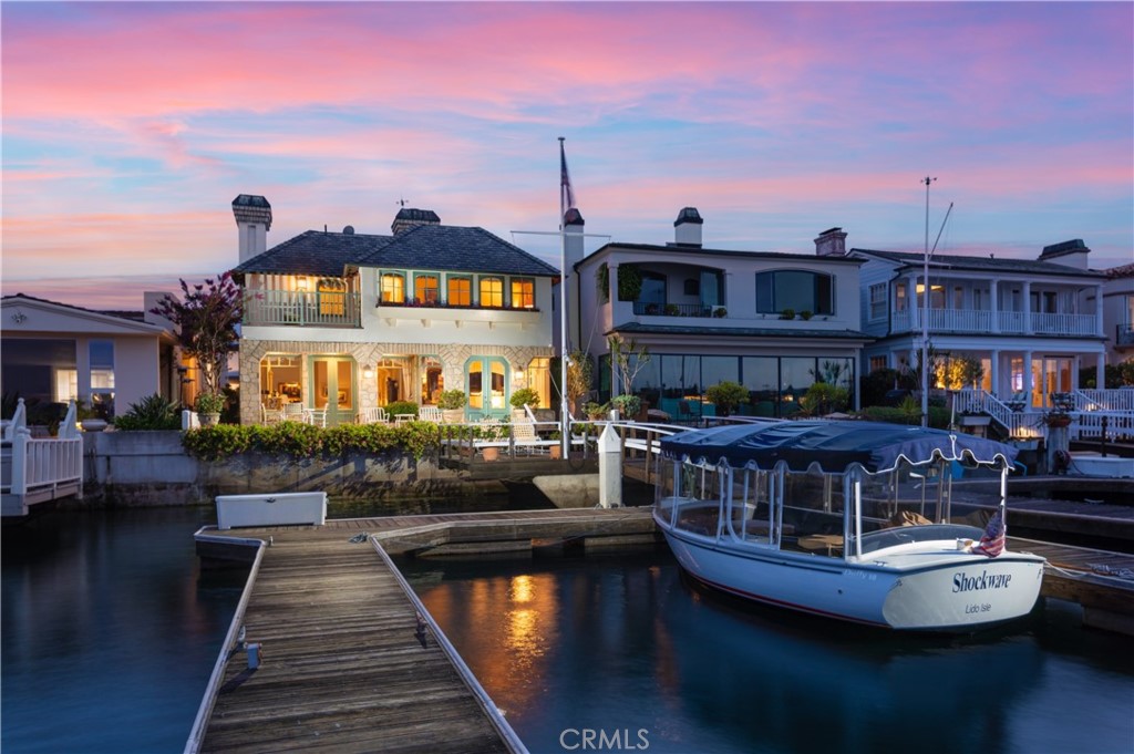 A rare opportunity to obtain a lifestyle others dream of. Set on a premiere waterfront lot on Lido Isle, this spectacular offering commands 40 feet of frontage and hosts a private dock accommodating a vessel up to 58 feet as well as a Duffy. Boasting approximately 4,376 square feet, the accommodations comprise of four large bedrooms, four-and-one-half bathrooms, formal dining room warmed by a fireplace, grand gourmet kitchen, and two opulent living areas with awe-inspiring bay, channel, and city light views. A refined aesthetic is curated throughout the estate by marble flooring, intricate built-ins, ornate millwork, high beamed ceilings, and designer light fixtures. French doors of the main level open to an expansive deck that beckons sophisticated bayfront entertaining and leads to the home's private dock. Designed to optimize space and function, the impressive chef's kitchen is accoutered with custom cabinetry, granite countertops, built-in desk space, and is equipped with reverse osmosis water filtration along with Thermador, Miele, and SubZero appliances. A wooden staircase rises to the second level where all four sumptuous en suite bedrooms reside including one that is currently being used as an office. Perfectly positioned to take full advantage of the water vistas, the resplendent master suite features a spacious private balcony and a spa-like bath with heated flooring, walk-in closet, dual sinks, vanity area, tub, and separate shower. Furthering the allure of the property are newer upstairs furnace and air conditioner (2017), security cameras, alarm system, and a soft water system. Residents of Lido Isle enjoy unrivaled amenities including tennis courts, beaches, clubhouse, and exclusive yacht-club opportunities, all just minutes from waterfront dining, shopping, ocean beaches, Lido Village, and Lido House Hotel.