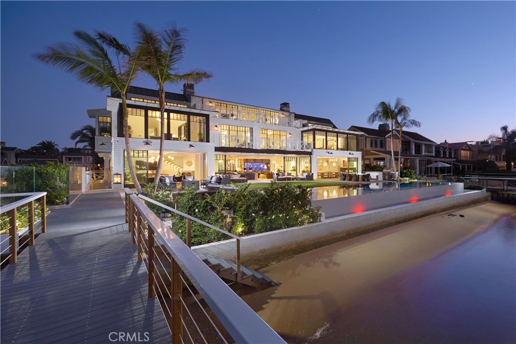 Nestled between the beach and the bay with appx. 90 ft. of frontage across 3 lots, 1813 East Bay commands distinction sight unseen, yet the caliber can only truly be appreciated firsthand. Designed by renowned architect Robert Sinclair, built by Patterson Custom Homes, and finished by Blackband Design, the home has a prestigious pedigree that represents innovative design & quality construction. The envy of every passerby is evoked with a towering façade and backyard fit with luxurious amenities including cooking area, fire pit, bay beach present at most tides, appx. 57-foot-long pool with underwater speakers, and new dock that can accommodate a minimum of 4 vessels. Approximately $1,000,000 in Riviera Bronze windows and doors blends the outdoors and indoors where sophisticated city living meets the comfort and casualness of the coast. Five bedrooms, 2 game rooms, 2 bars, 2 gourmet kitchens, executive office, craft room, theater, gym, mudroom, and sauna are complemented by striking design elements including precision millwork, a floating, underlit staircase beneath oversized skylight, fireplace within appx. 16-ft. stone hearth and mantle, and 1,100-gallon aquarium. State-of-the-art technology operates the home: Whole-house automation and security with surveillance, 6 HVAC compressors, 4-stop glass elevator, 5-car garage with EV plugs-ins, 3 Tesla solar batteries, and 16 kW Panasonic solar panels that can perpetually power the critical elements of the house during power outage.
