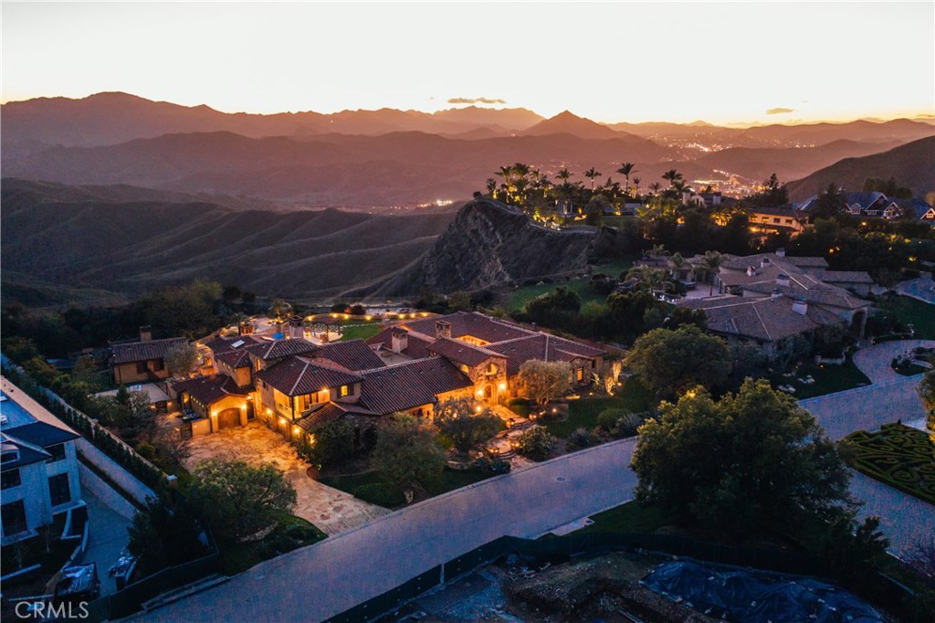 The Quintessential Calabasas Lifestyle Estate behind the highly coveted gates at The Estates at The Oaks. This refined Old World Estate has a spectacular largely single level floor plan with incredible scale and architecture. Beautifully crafted with detail and luxury proportions, this estate is approximately 11,000 sq ft of living space. Boasting features from a generous master suite with two walk in closets, large office library, spacious game room and home theater, incredible family room open to the kitchen and open to the expansive grounds and panoramic views. The bonus second level includes two large bedroom suites and an incredible oversized outdoor terrace and top of the world panoramic composition.
Incredible indoor and outdoor flow from every aspect of the property. Spectacular outdoor living at its finest. A detached guesthouse with kitchen. The grounds are private and perfectly positioned for entertainment and retreat. A rare offering situated on the highest elevated street in the Estates with incredible views of the endless conservancy.